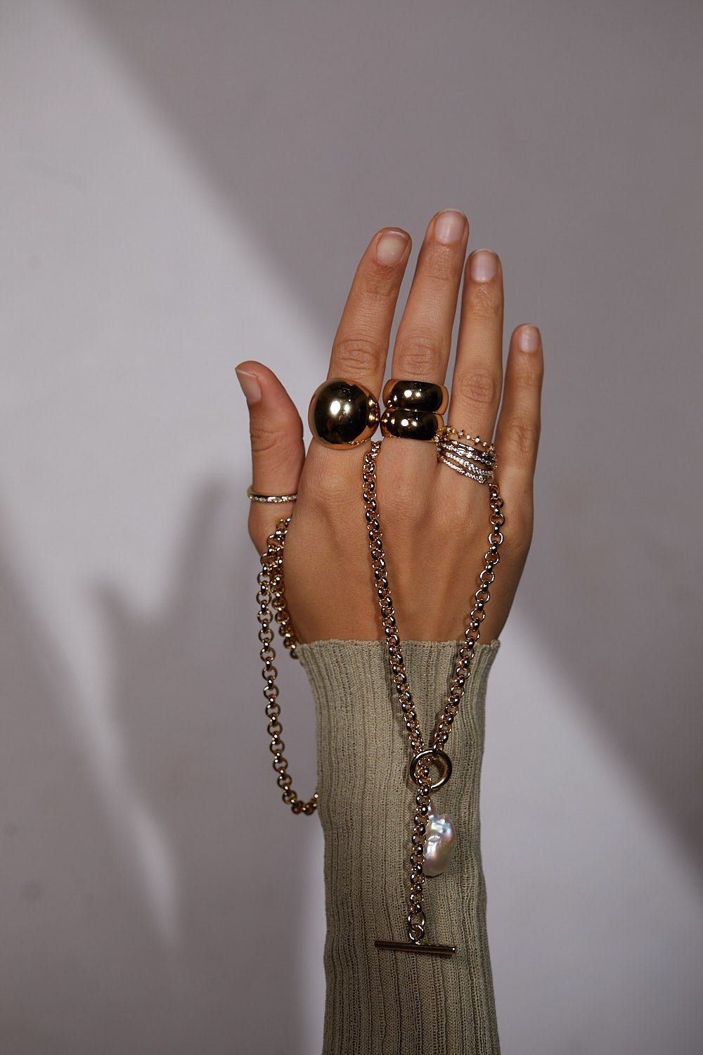 a woman's hand with a chain and ring on it