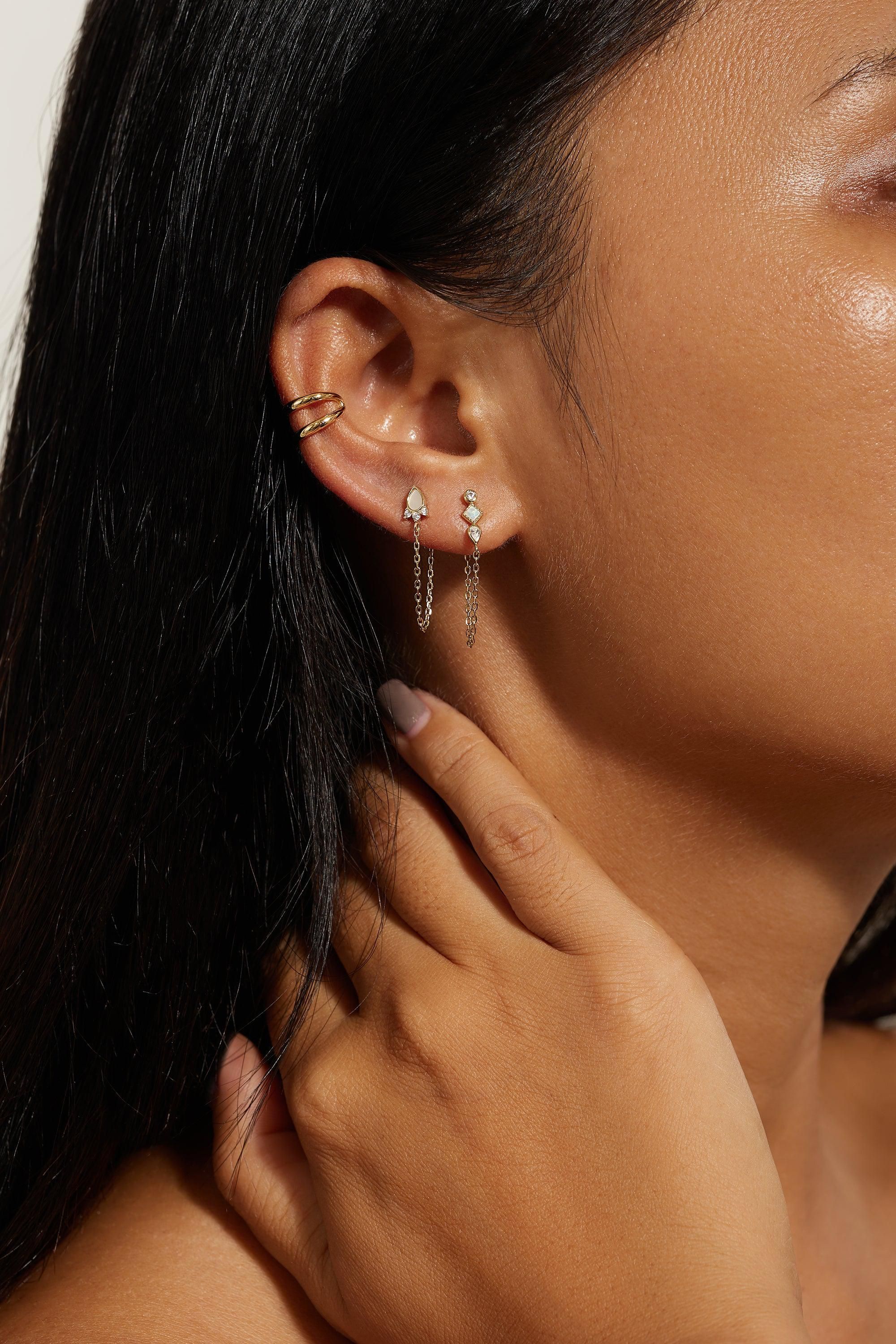 a close up of a person wearing a pair of earrings