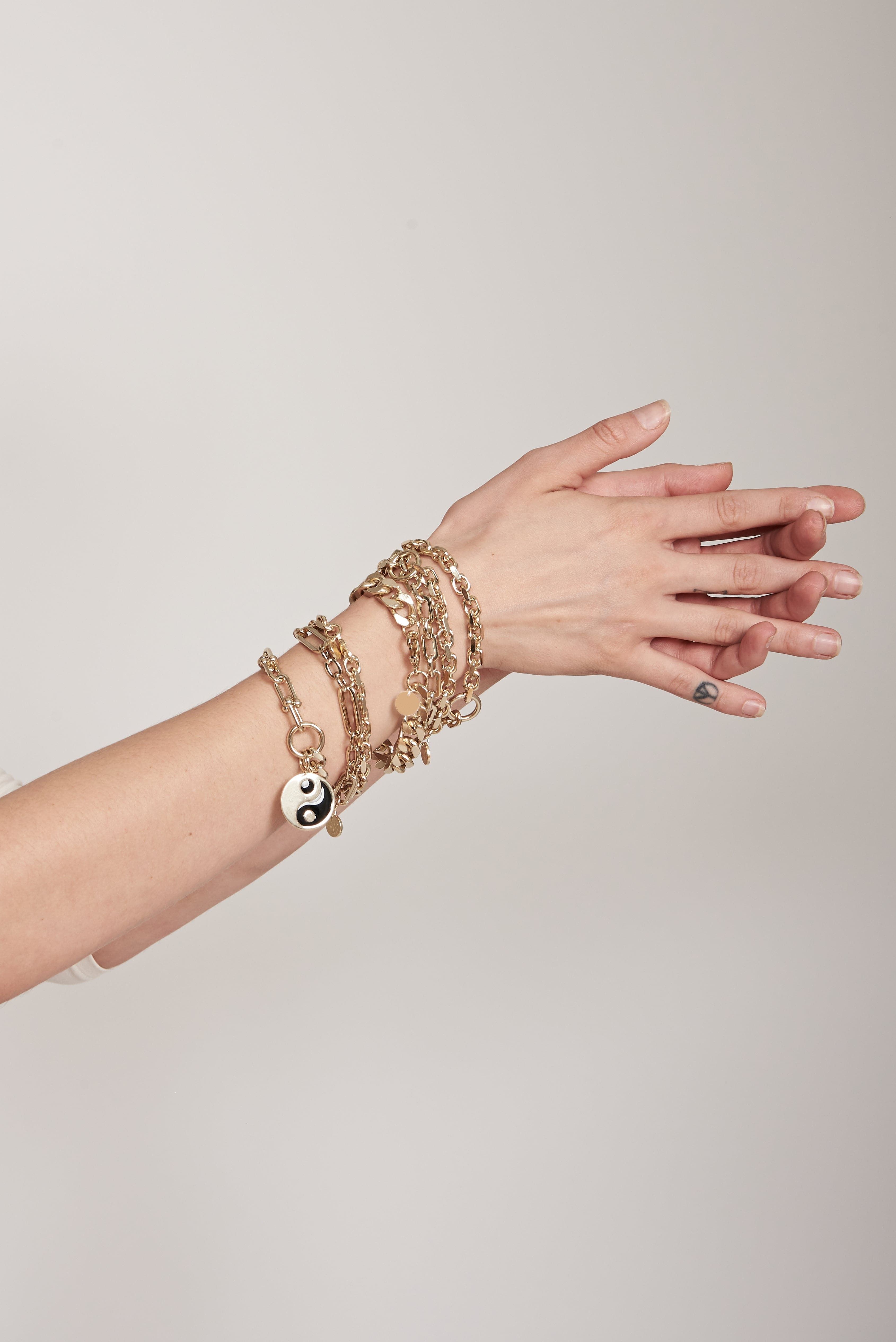 a woman's arm with a bunch of bracelets on it