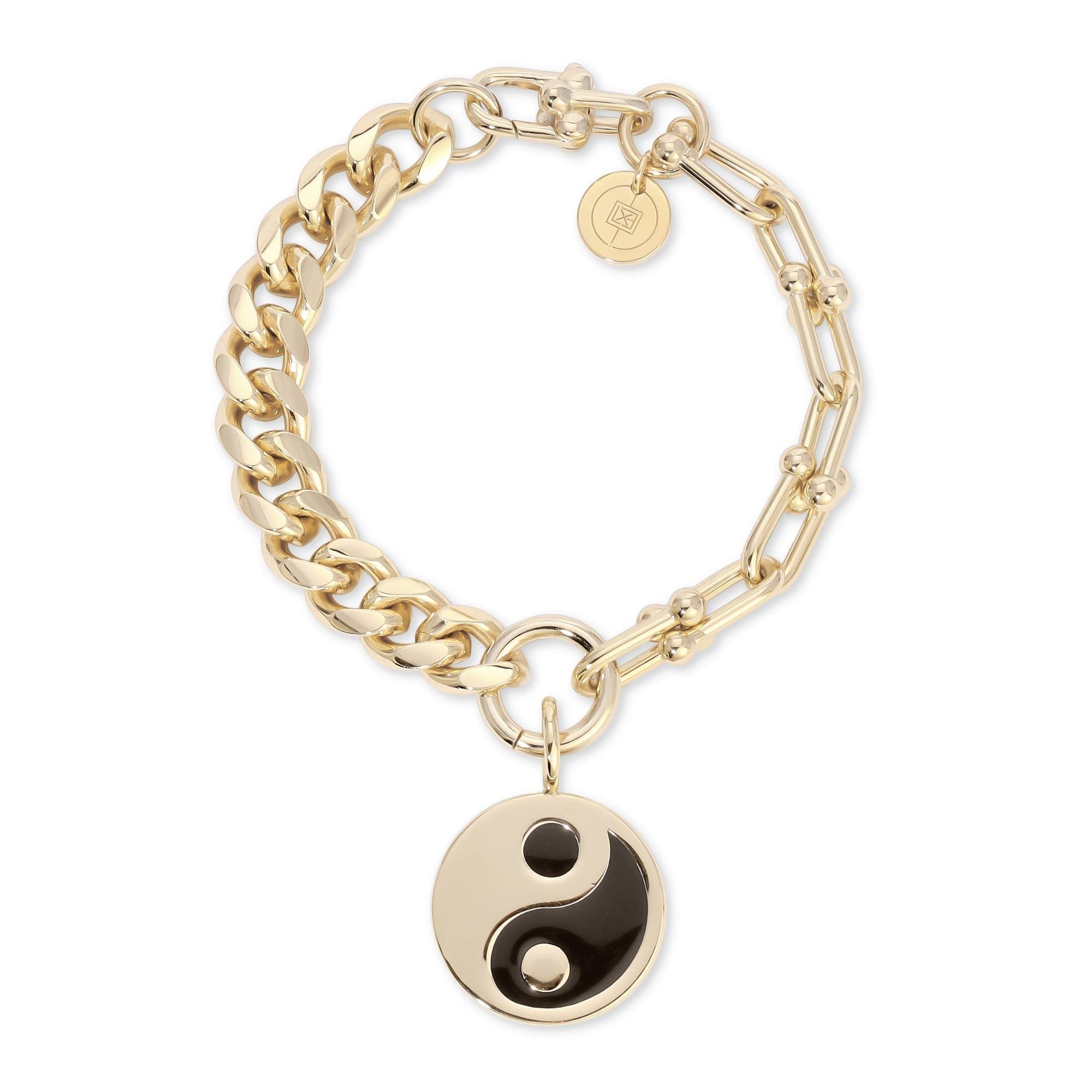 a gold chain bracelet with a yin symbol charm