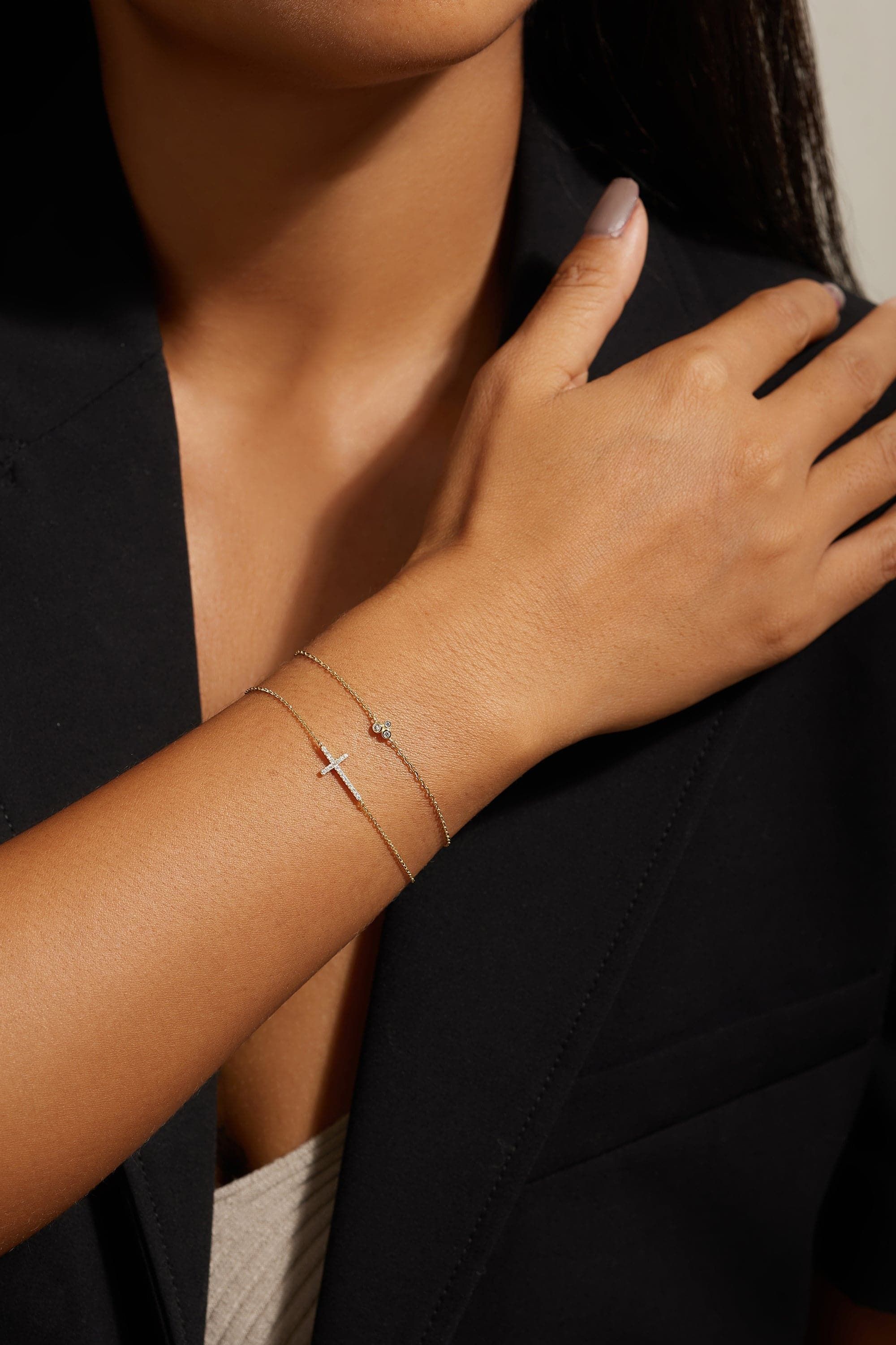 a woman wearing a bracelet with a cross on it