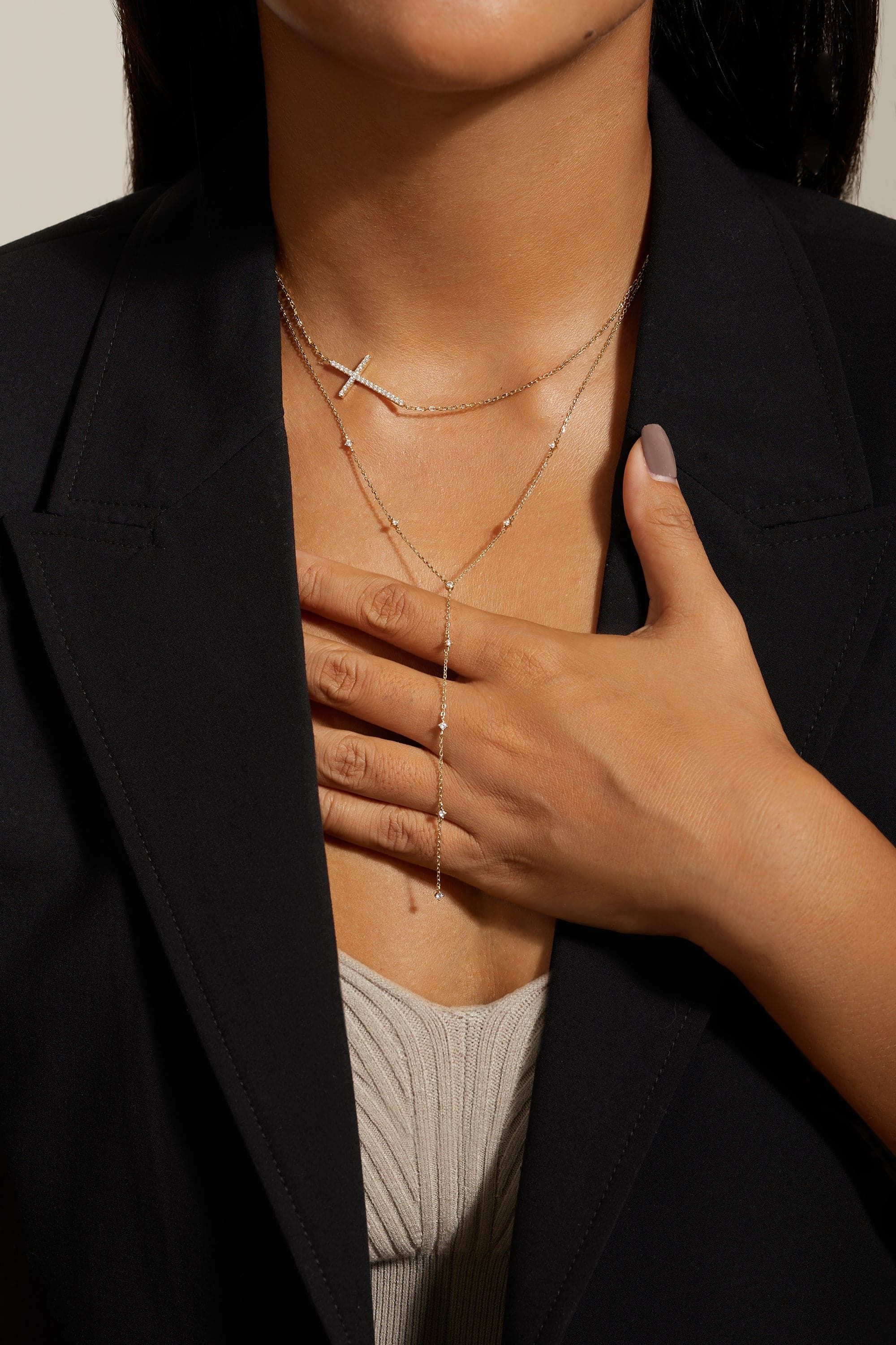 a woman wearing a black jacket and a cross necklace