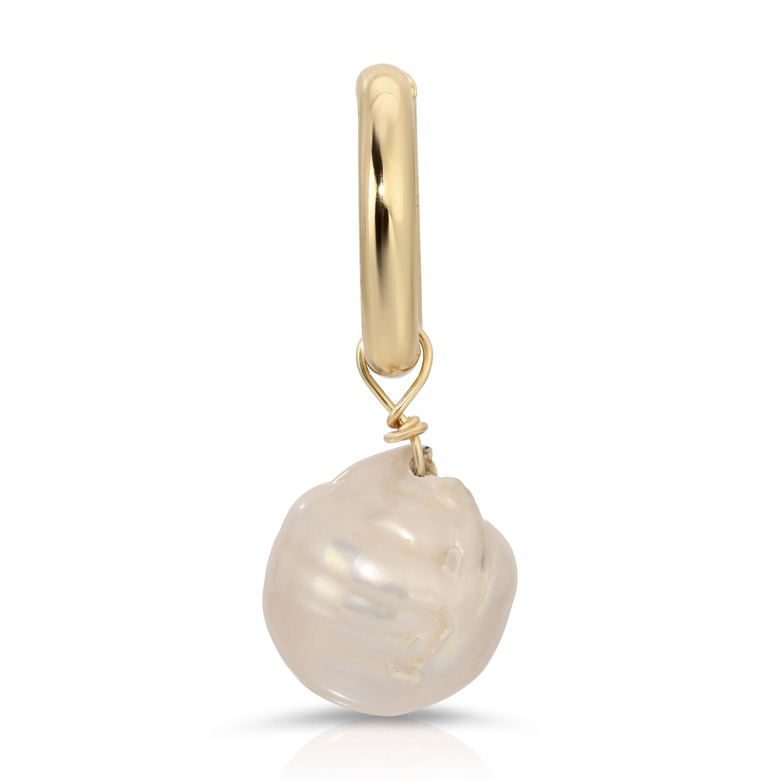 a pearl is hanging from a gold plated charm