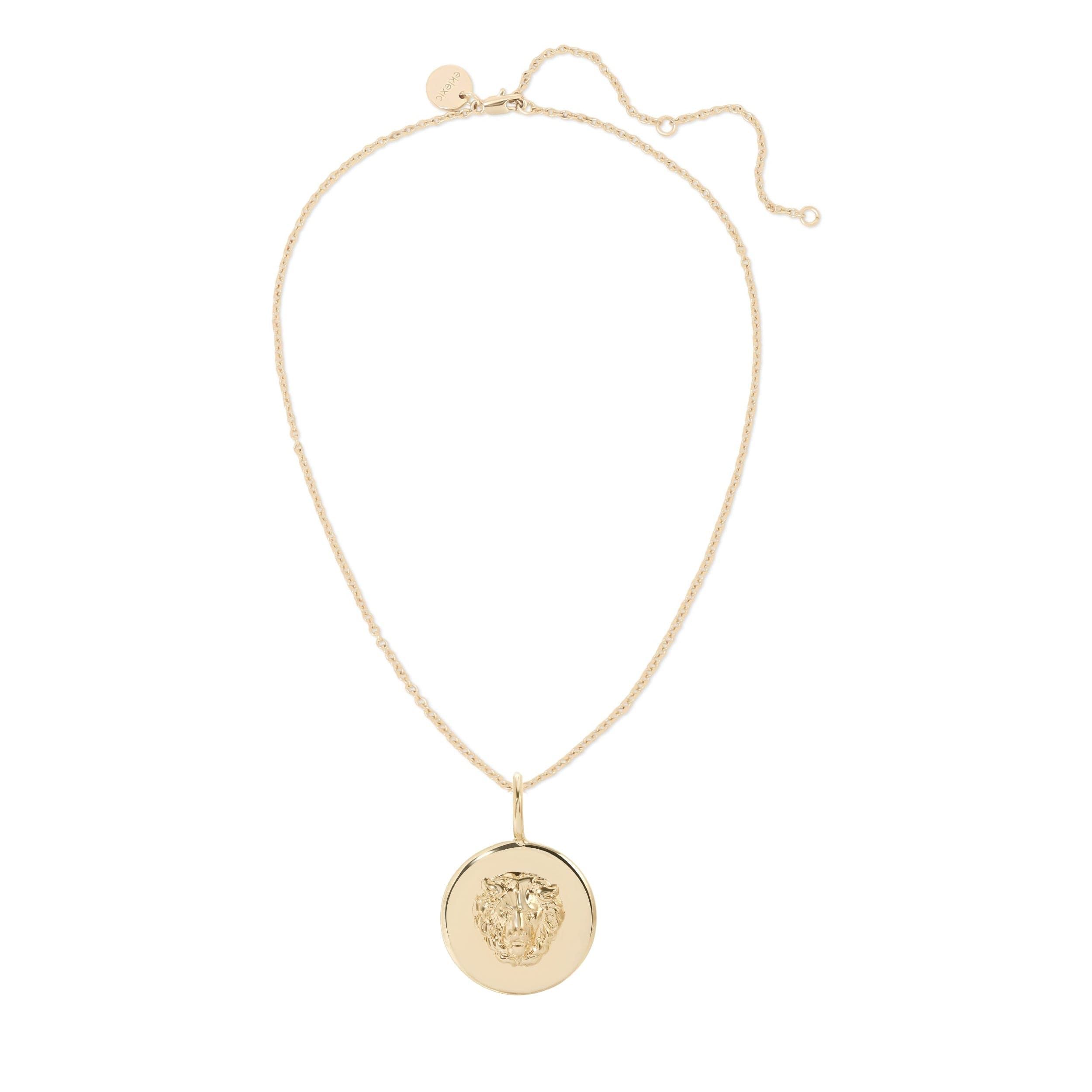a gold necklace with a medallion on a white background