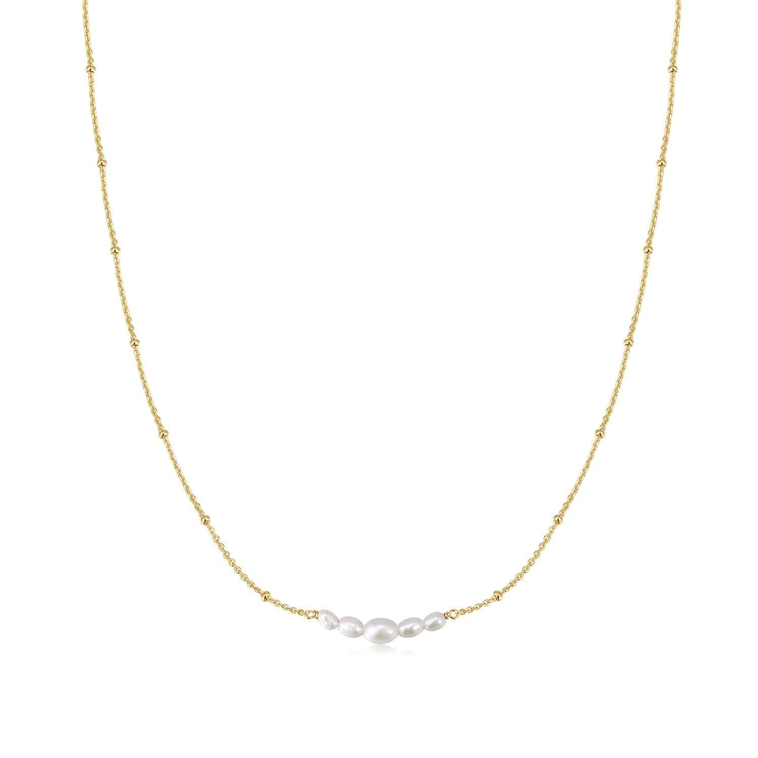 a gold chain with three pearls hanging from it