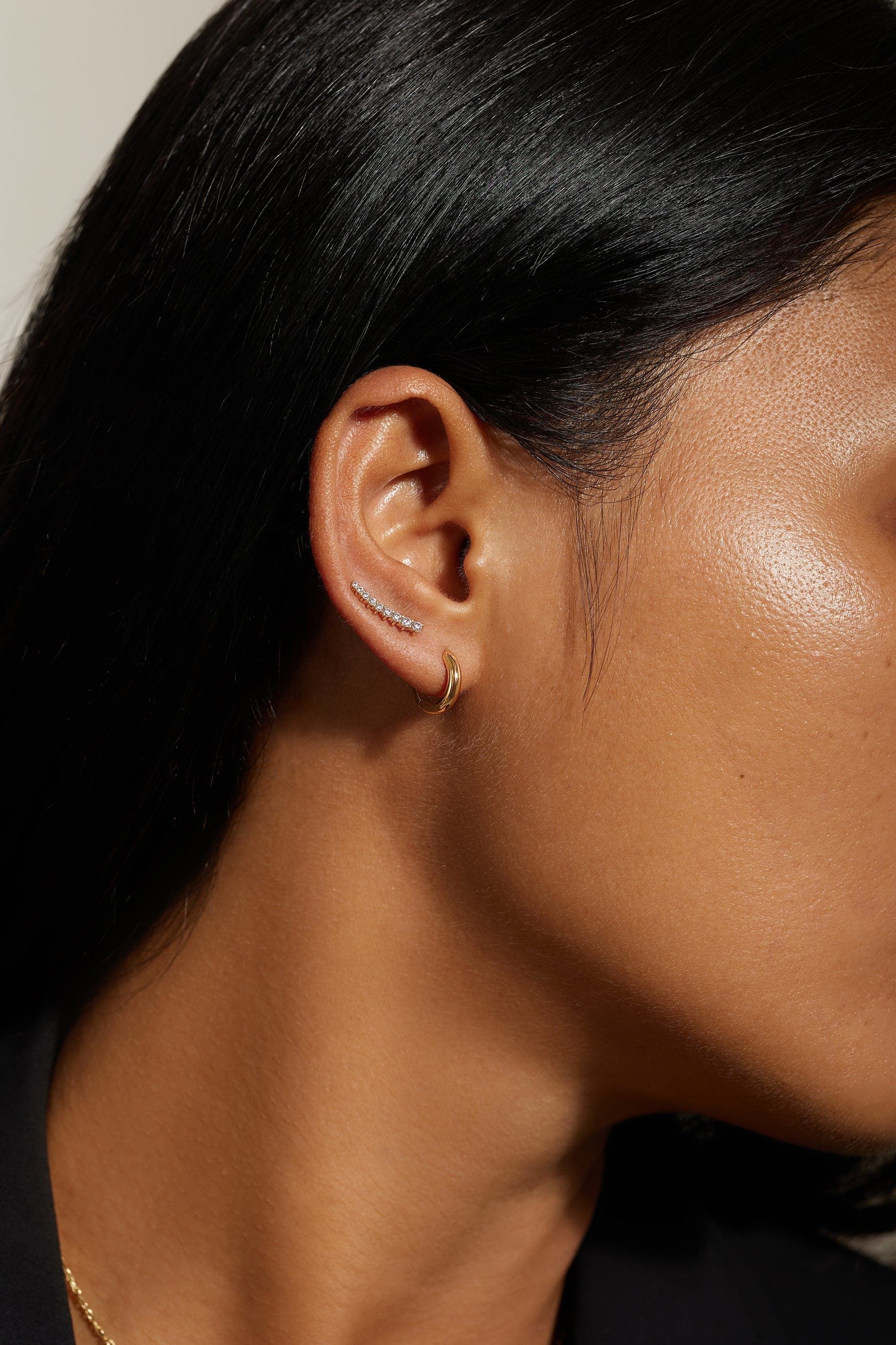 a close up of a person wearing a necklace and earring