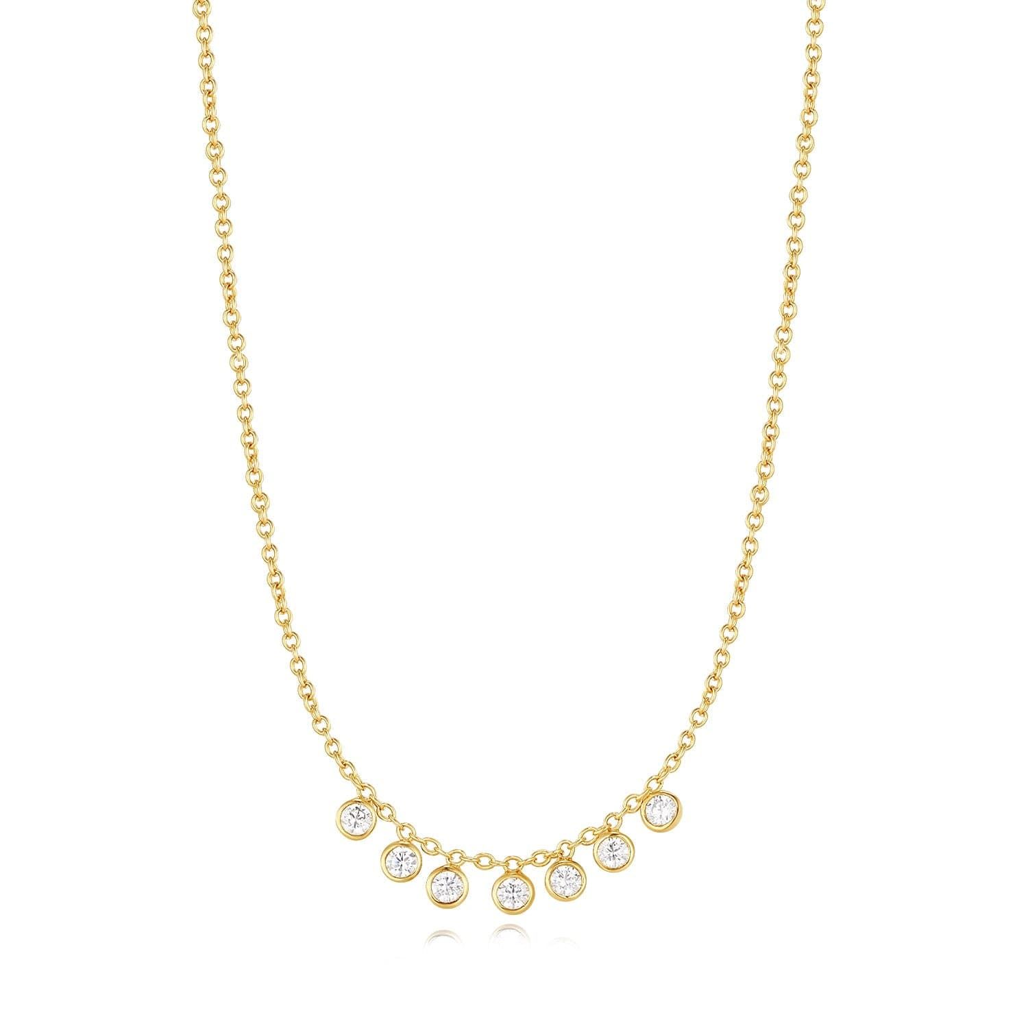 a gold necklace with five diamonds on a white background