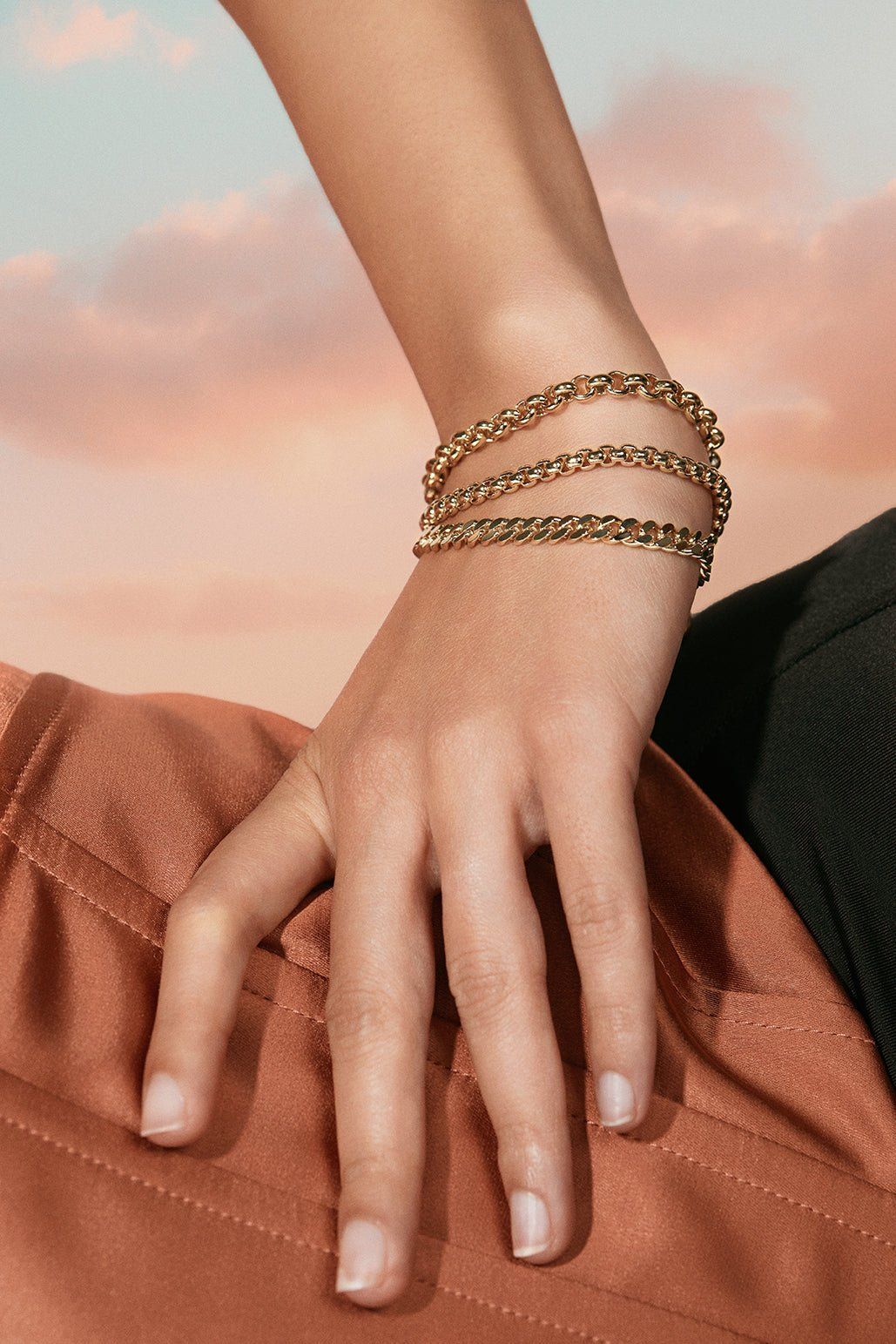 a woman's hand wearing a gold chain bracelet