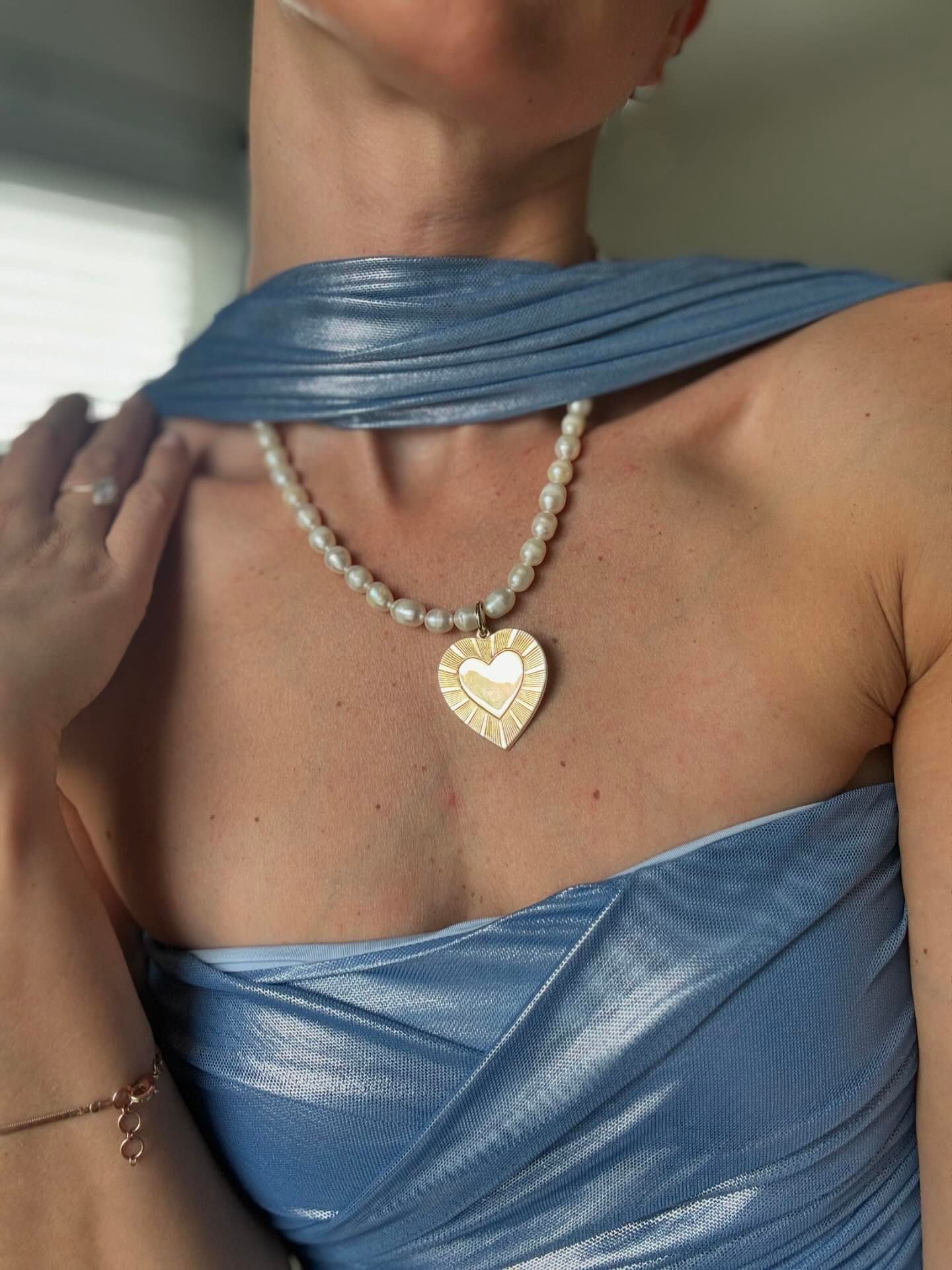 a woman wearing a necklace with a heart pendant