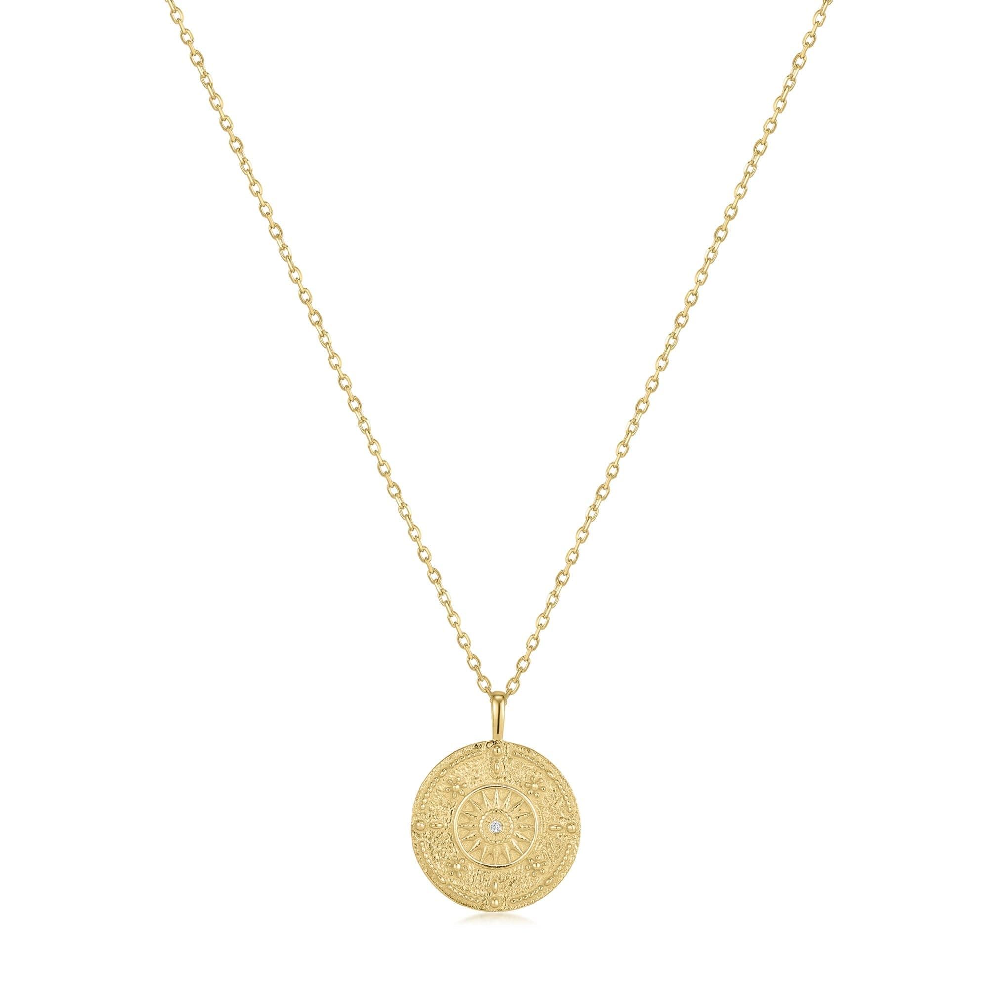 a gold necklace with a coin on it