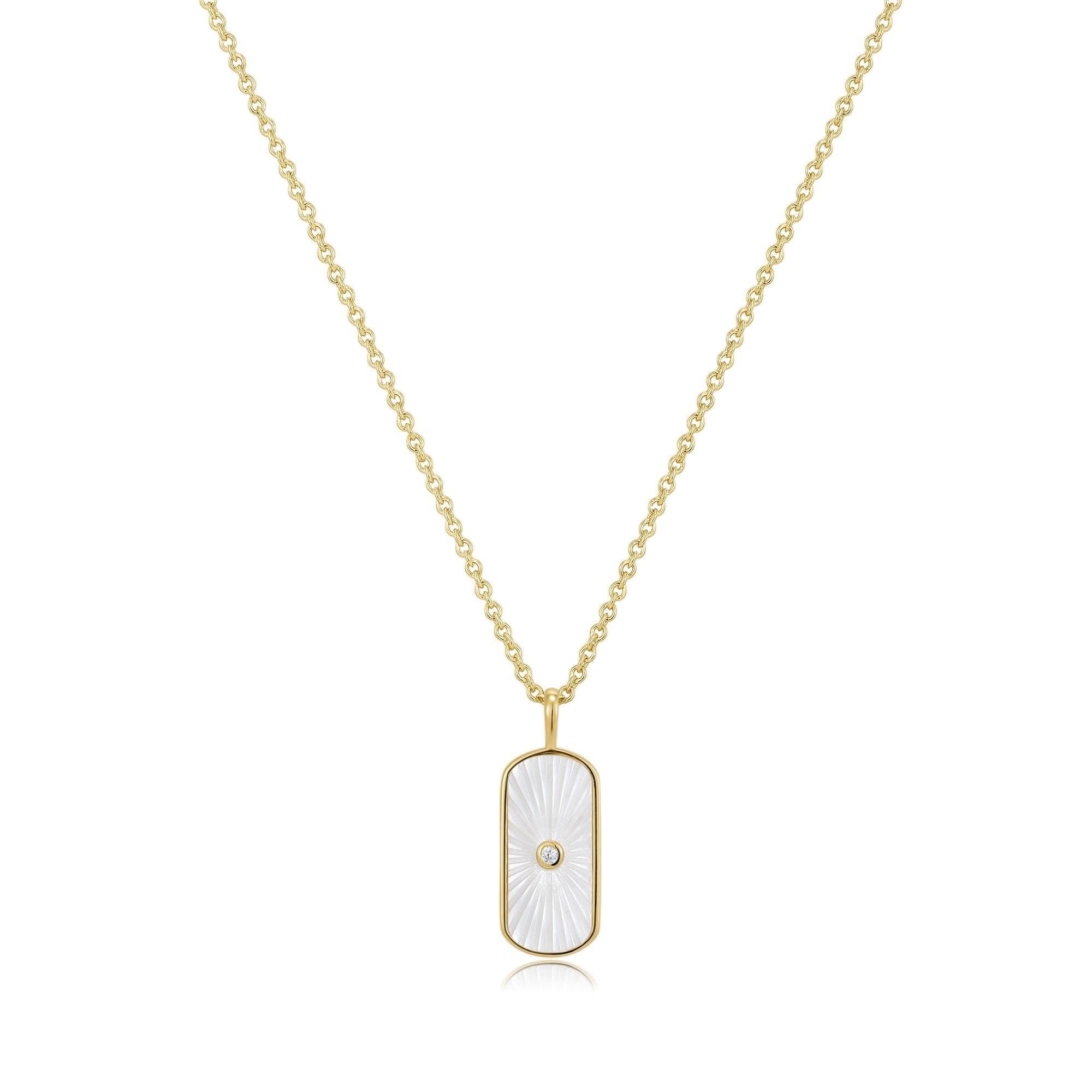 a gold plated necklace with a white shell on it