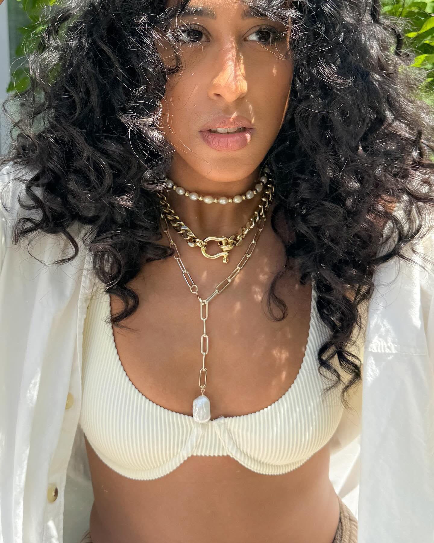 a woman wearing a white bikini top and a chain around her neck