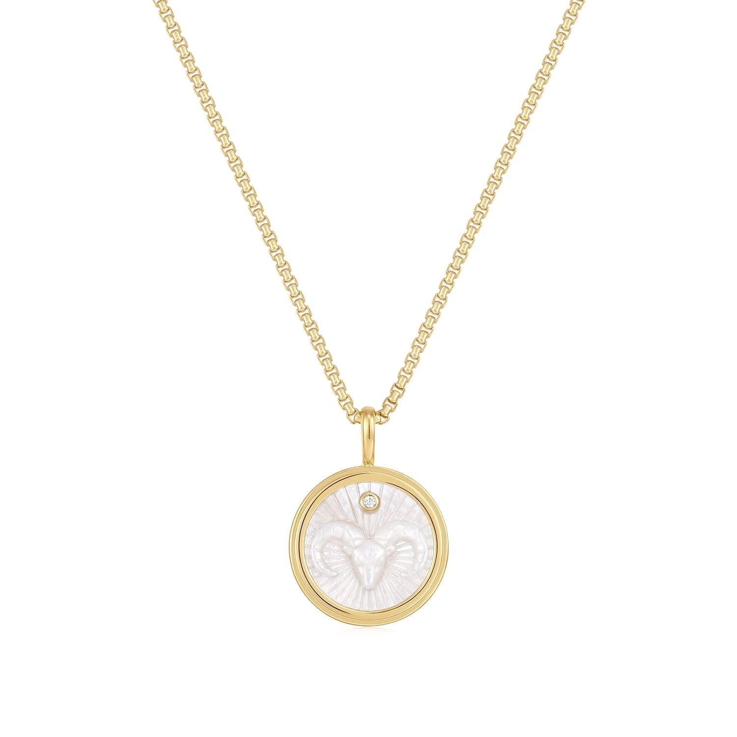 a gold necklace with a white shell in the center