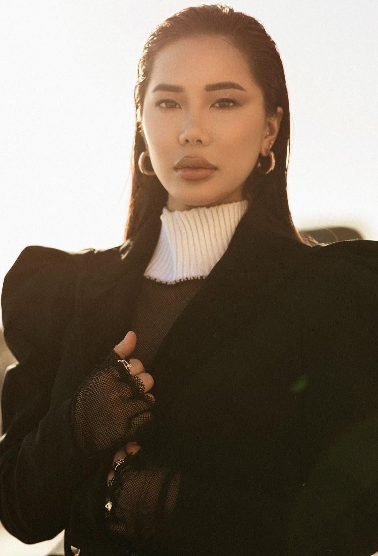 Stylish woman wearing Baby Alexis Hoops and a black blazer with recycled brass square