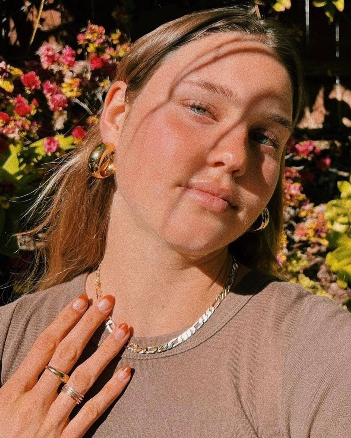 Young woman wearing a Baby Axel Necklace featuring a Figaro chain and lobster clasp