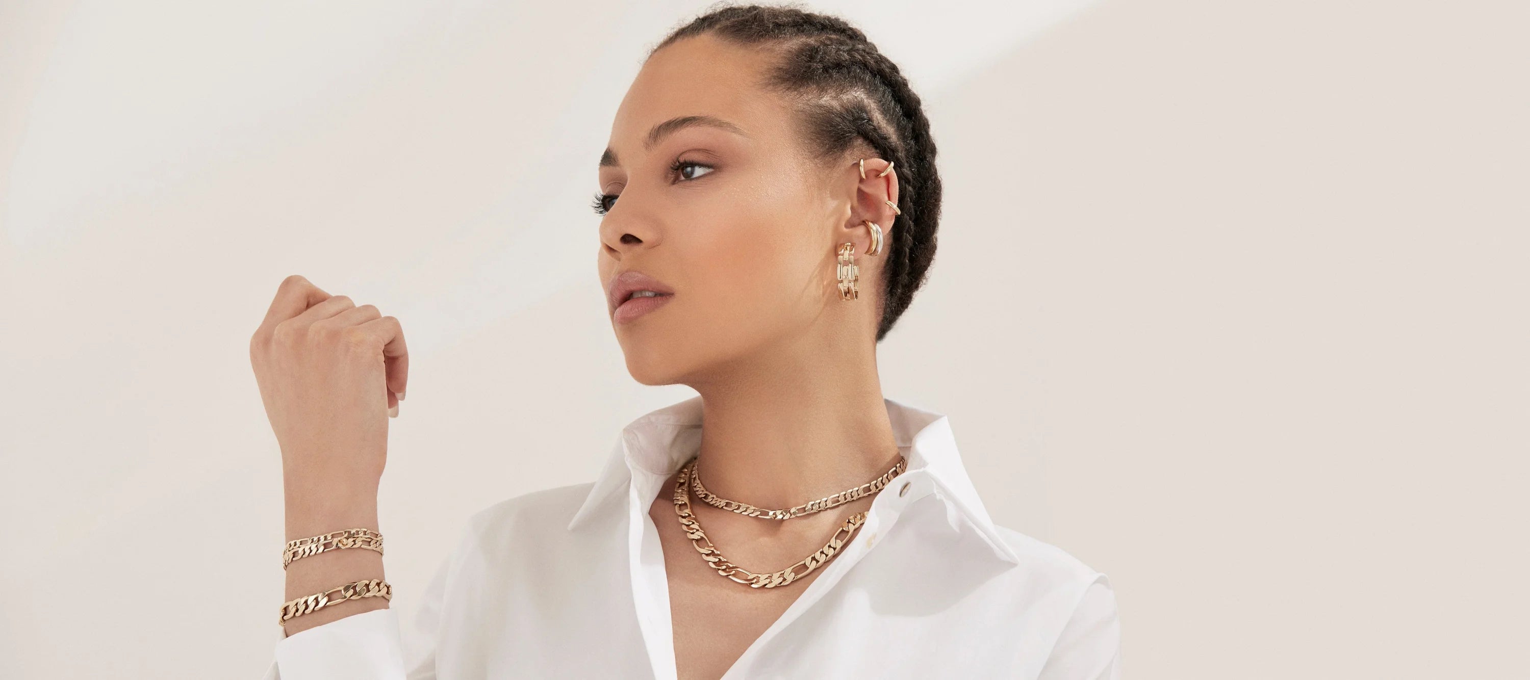 Woman wearing a gold Baby Axel Chain Necklace with Figaro chain and lobster clasp
