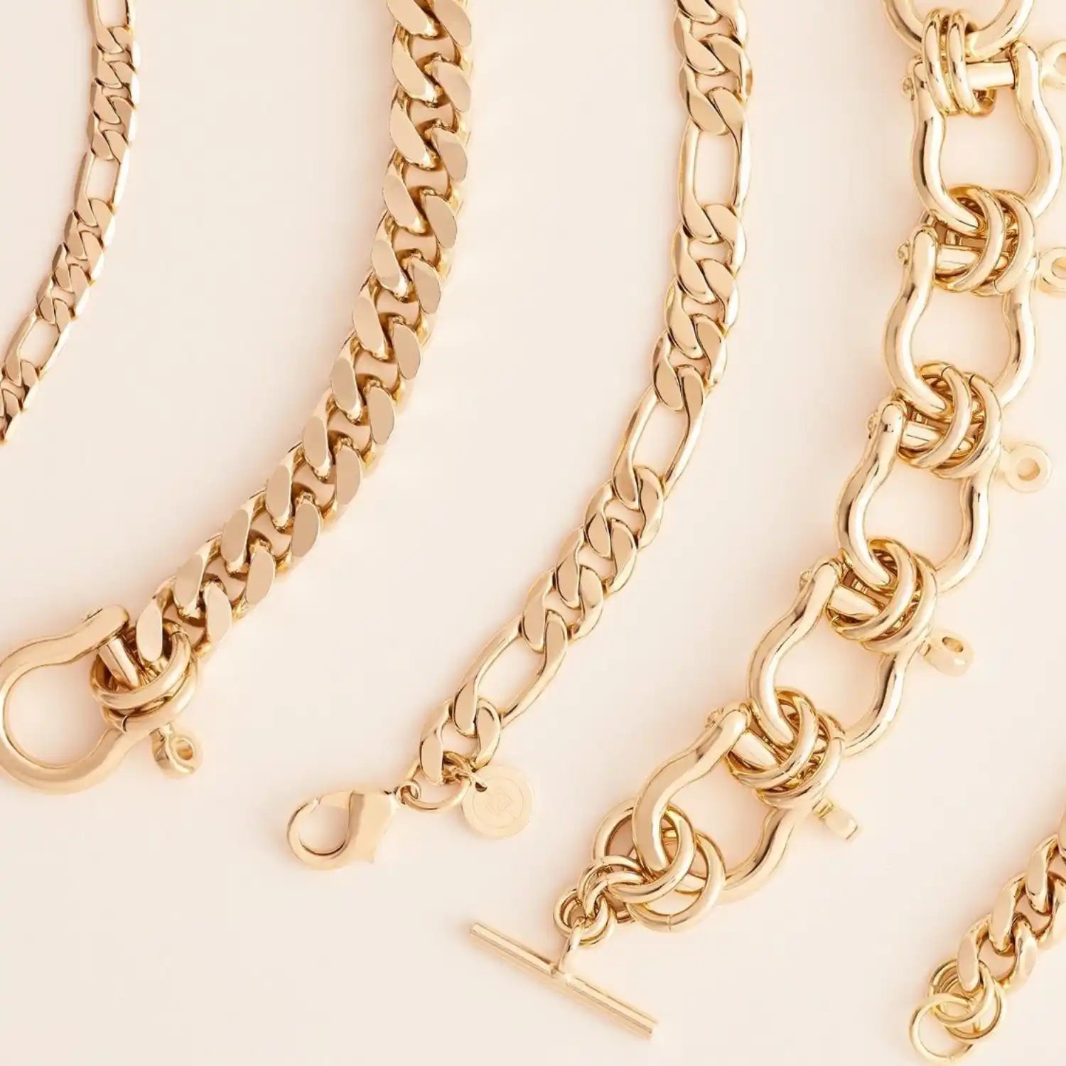 A collection of gold-colored chain bracelets with various link styles and clasps.