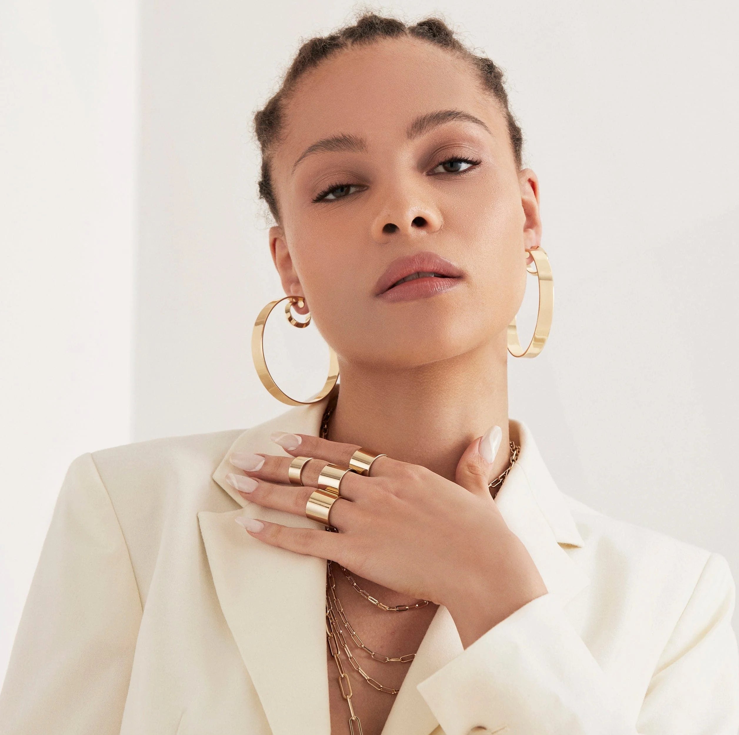 Woman wearing gold jewelry with 2.5 Skylar Hoops dangling stylishly
