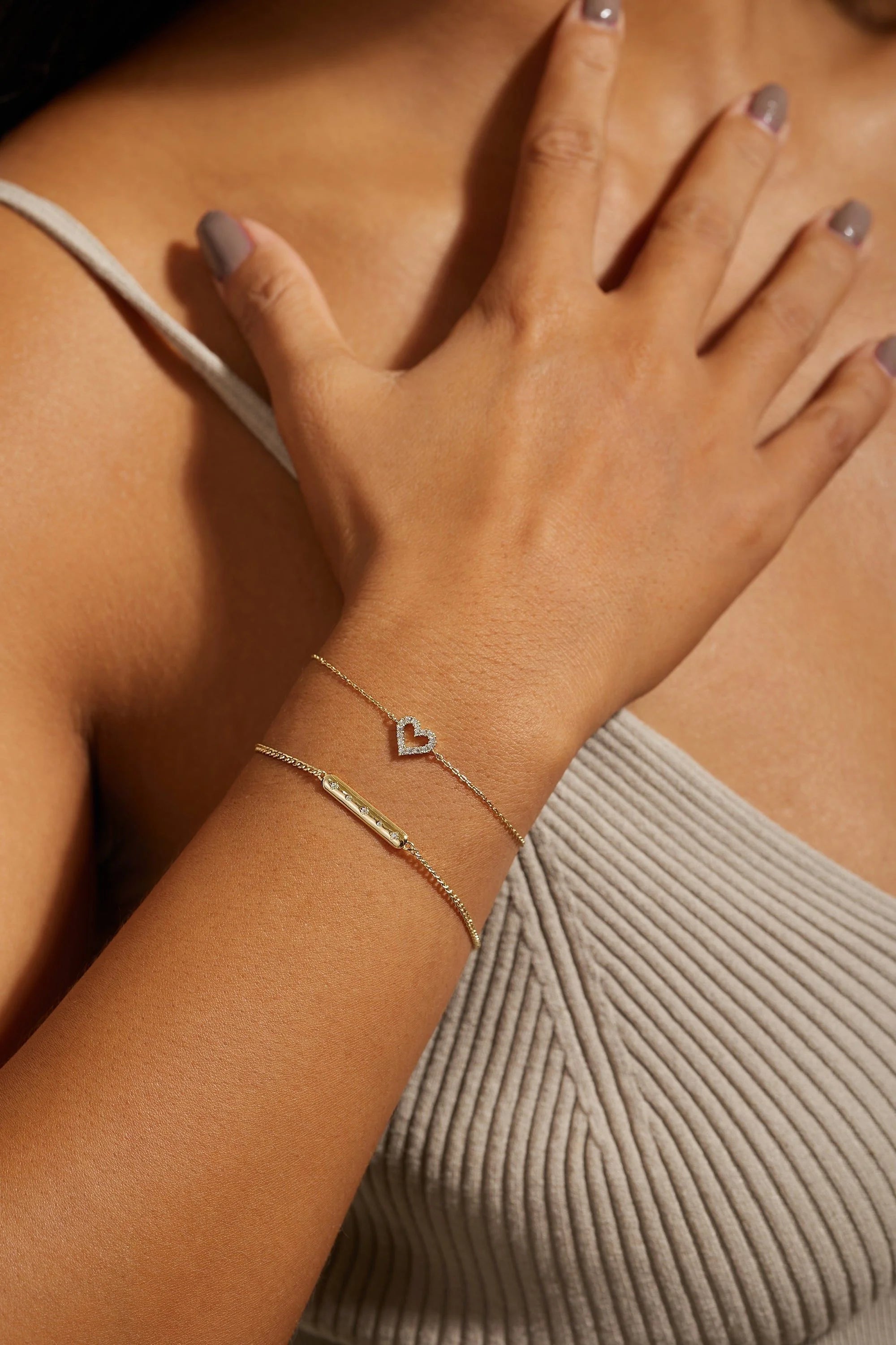 Woman’s arm with Micro CZ Heart Bracelet and bar charm, light gray nail polish