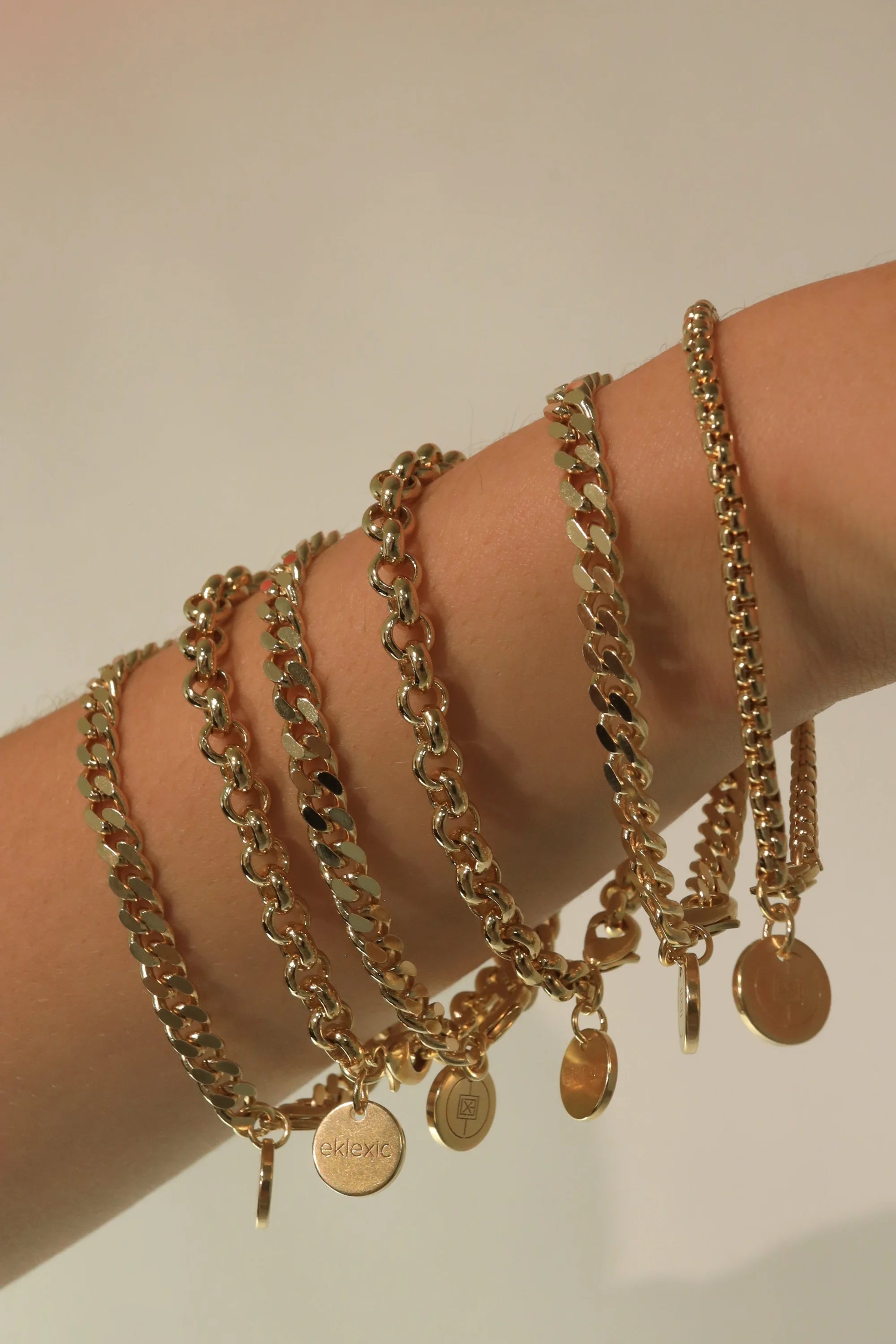 Gold chain bracelets with circular pendants from Micro Royal Rolo Chain Bracelet collection