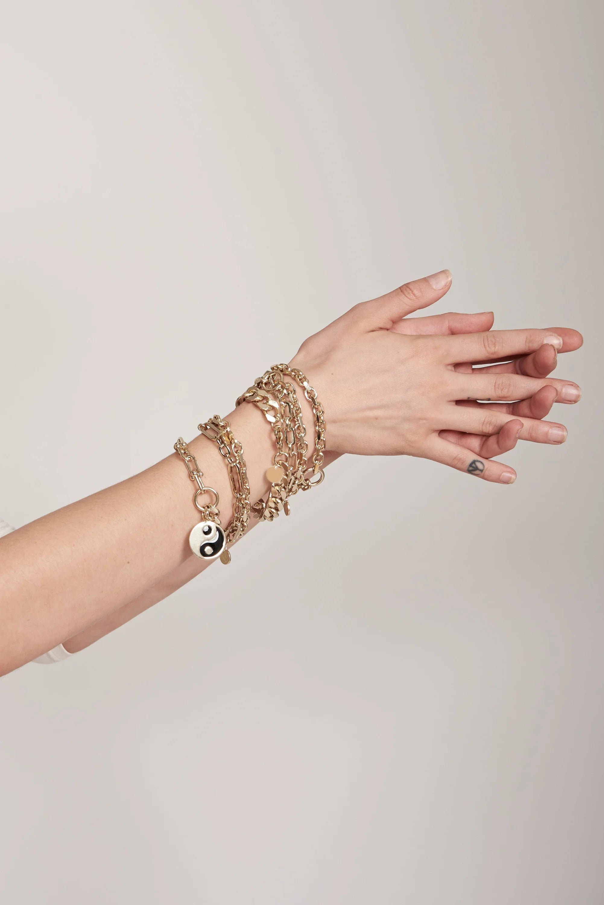 Gold-toned charm bracelets with a large Enamel Yin Yang Pendant perfect for style