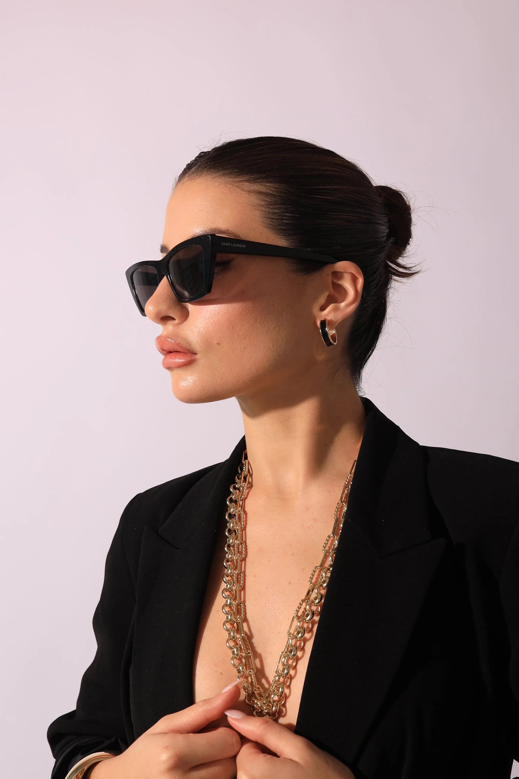 Stylish woman wearing sunglasses and gold 3/4 inch enamel hoop earrings