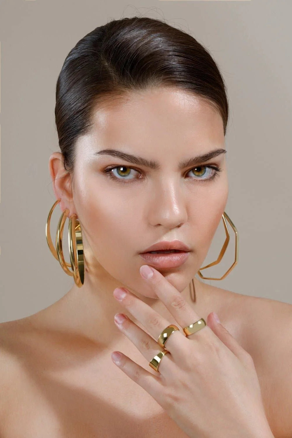 Woman showing off Jerry Hoops gold jewelry in a stylish casual look