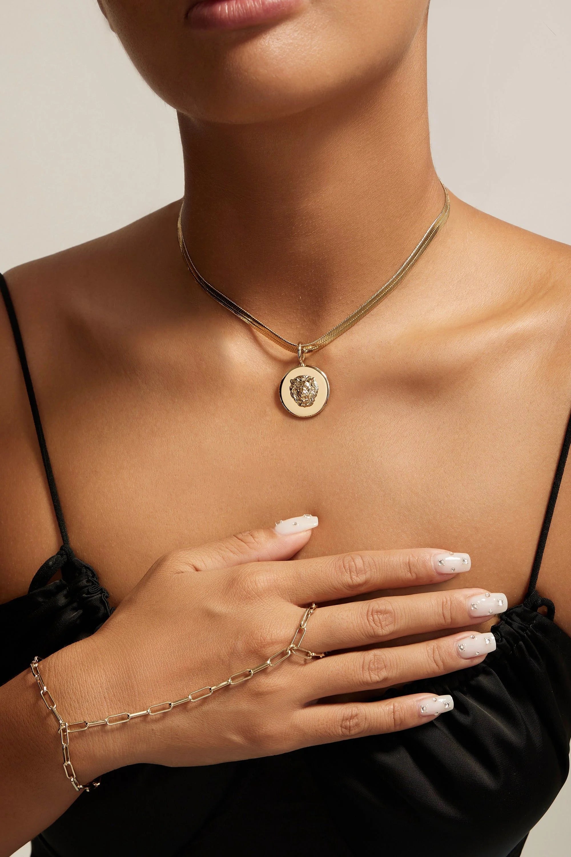 Gold necklace and hand chain featuring the Leni Lion Pendant for a stylish look