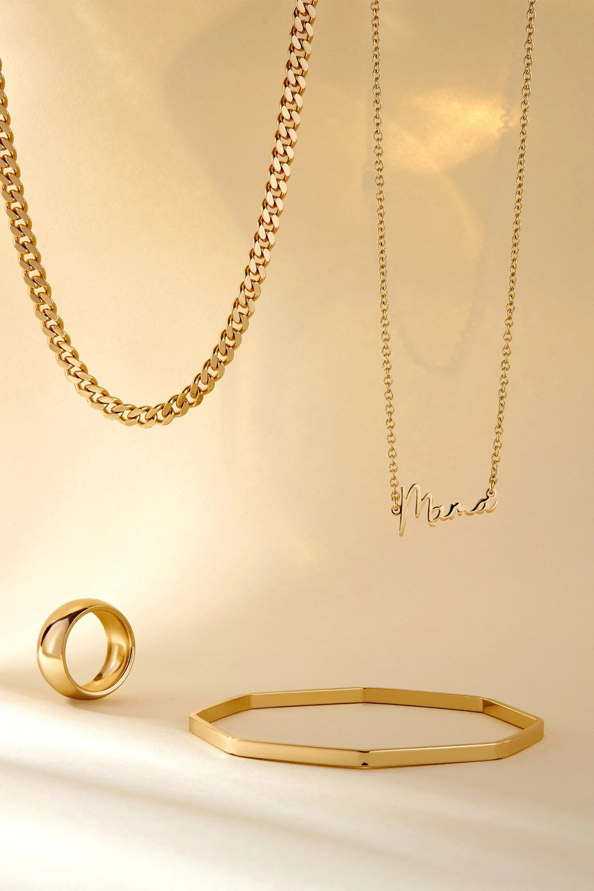 Gold Jewelry Collection featuring the Dainty Script Mama Necklace on display