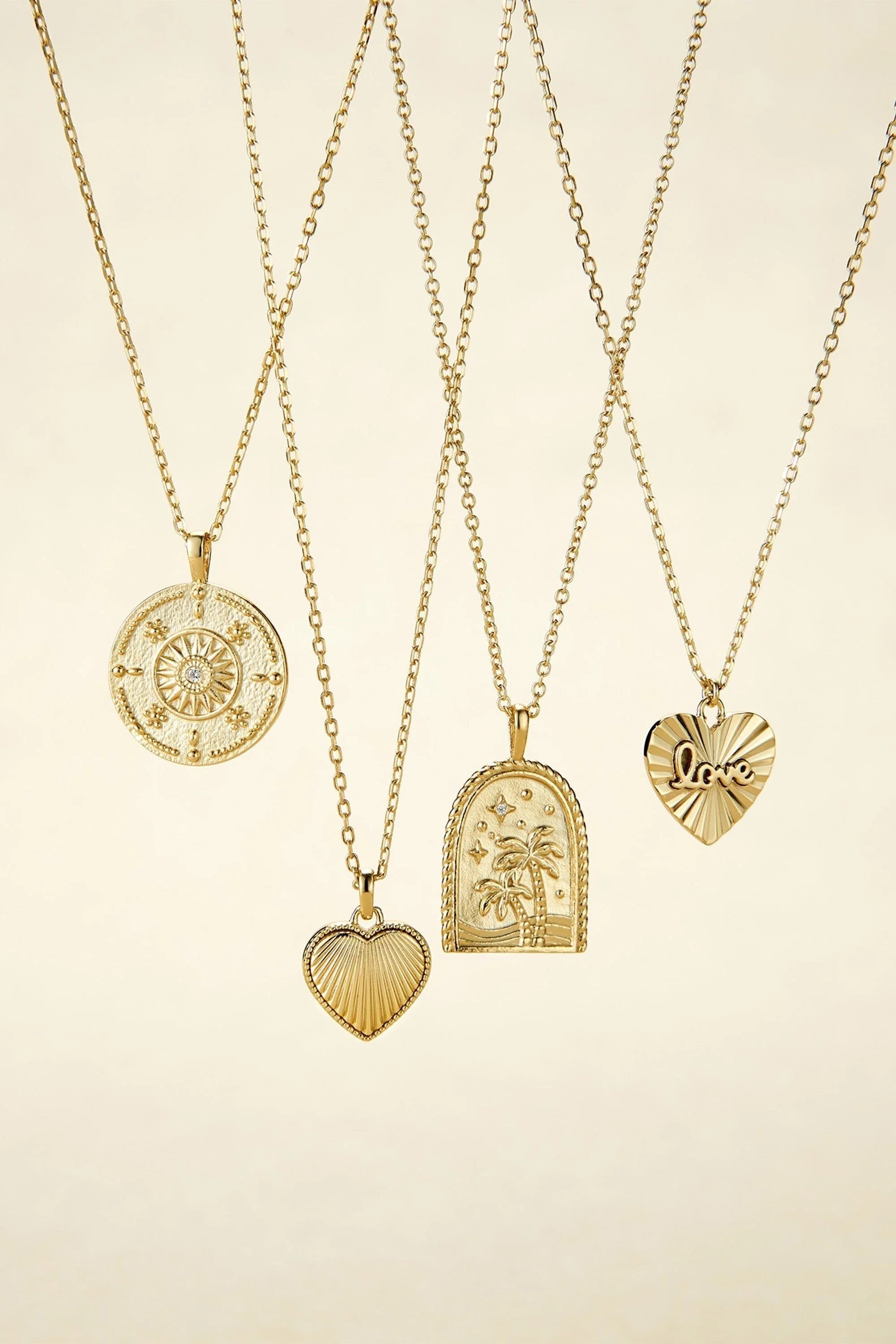 Five gold-tone necklaces with unique pendants from the Mini Love Heart Charm Necklace collection