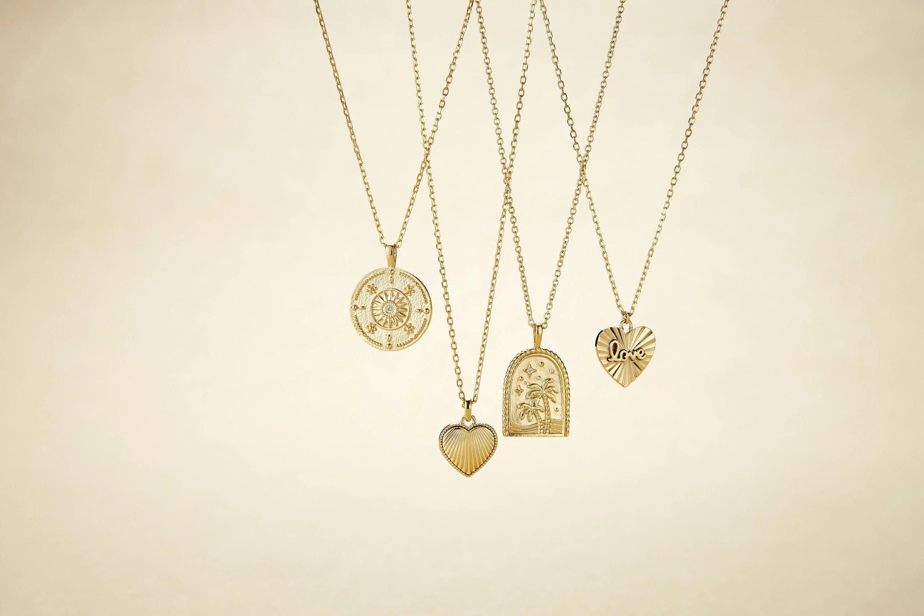 Five gold necklaces with unique pendants, including a Palm Tree Pendant Necklace