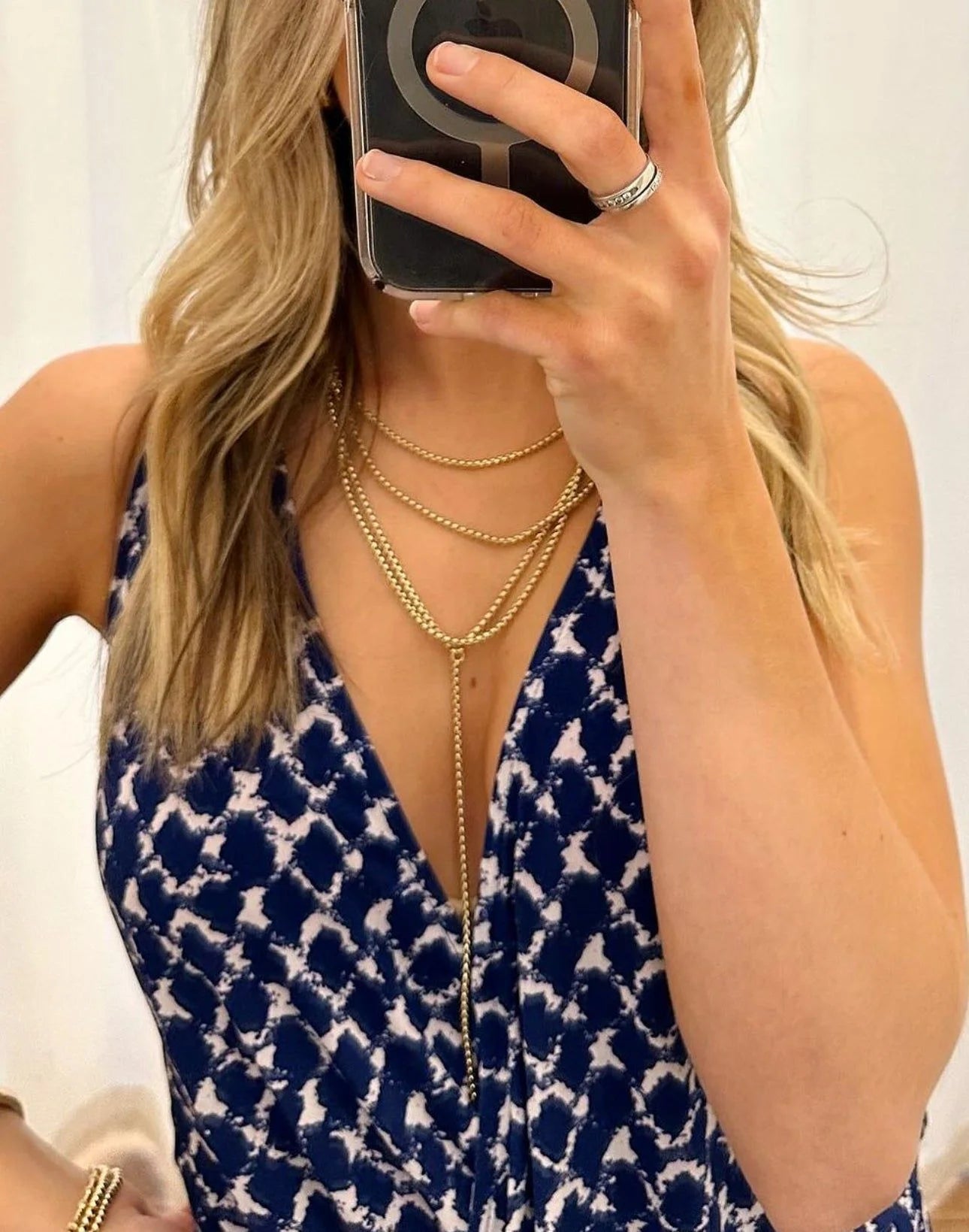 Woman wearing a shiny gold layered necklace from the Triple Layer Thin Luciana Box Chain collection