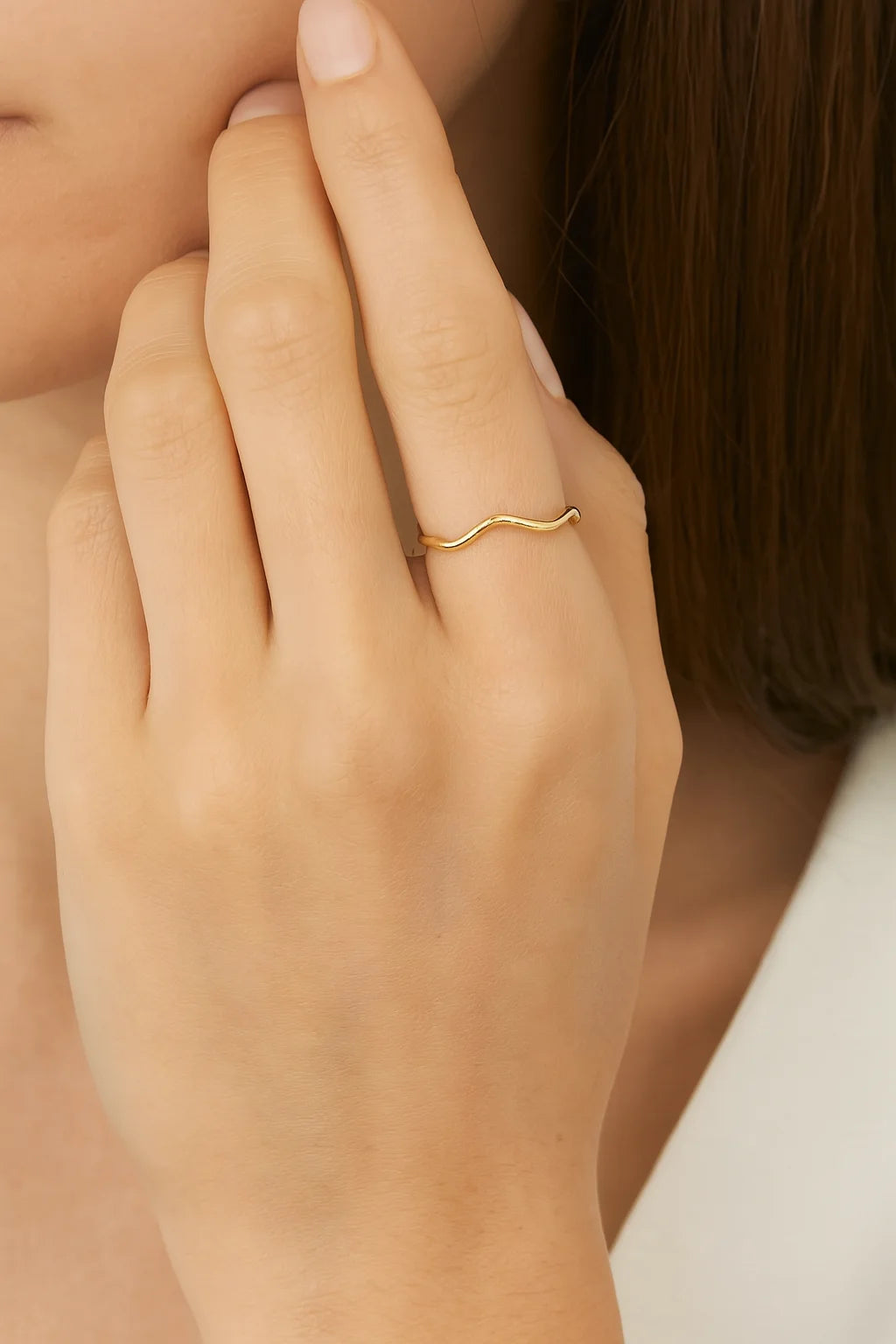 Delicate wavy gold ring on finger from Super Thin Wavy Ring collection