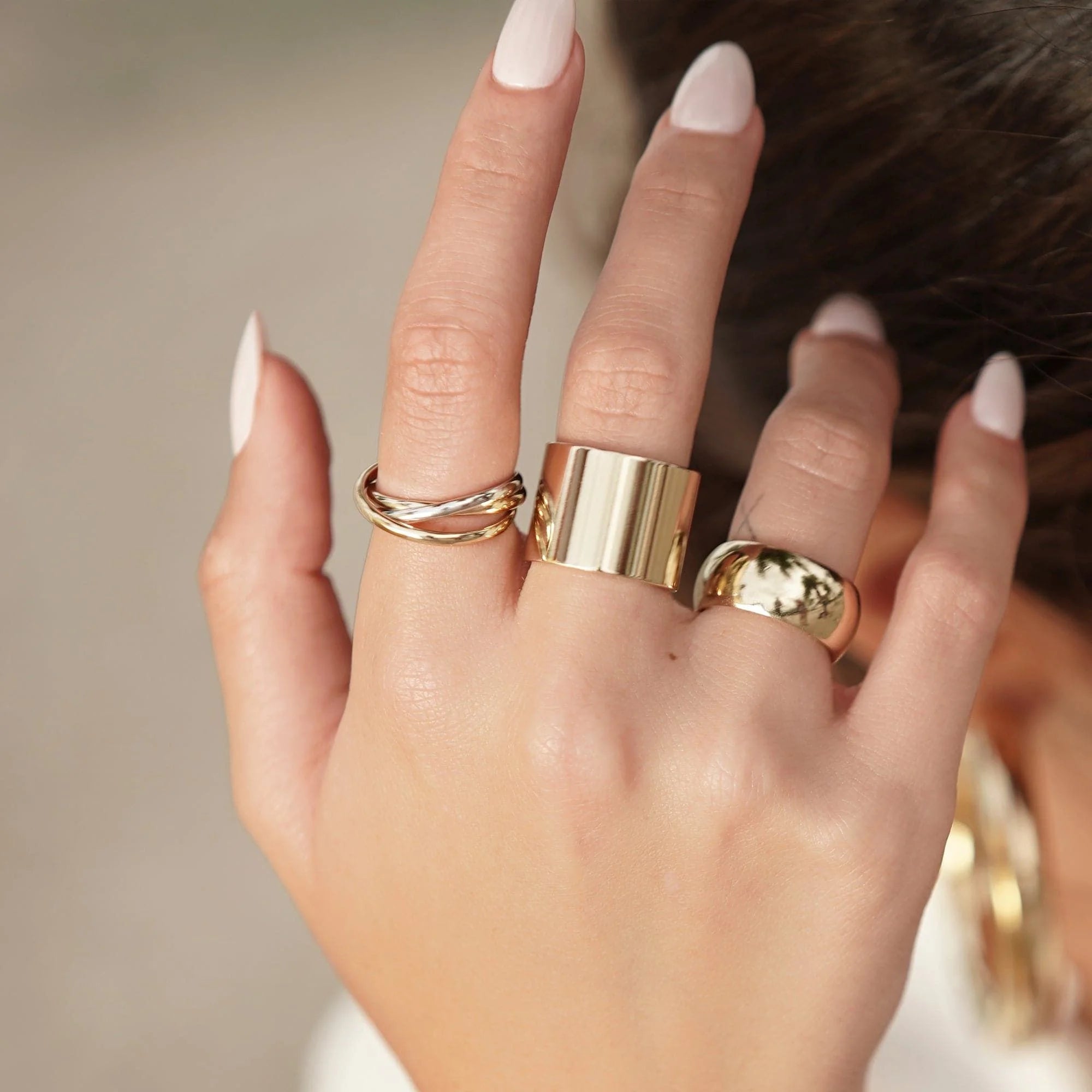 Hand with gold rings showcasing the stylish Thick Flat Ring product