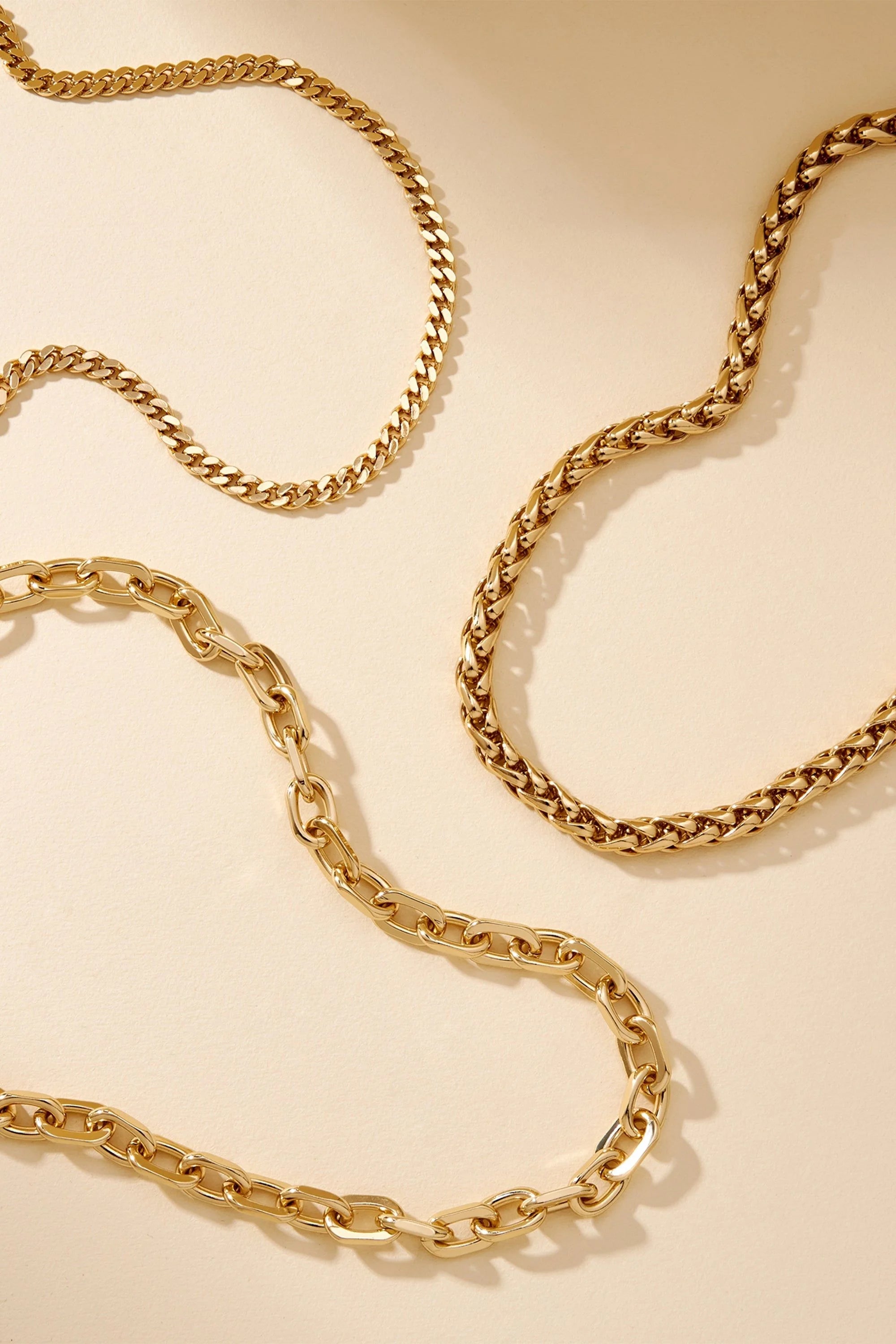 Gold chains from the Lennon Necklace collection displayed beautifully in this image