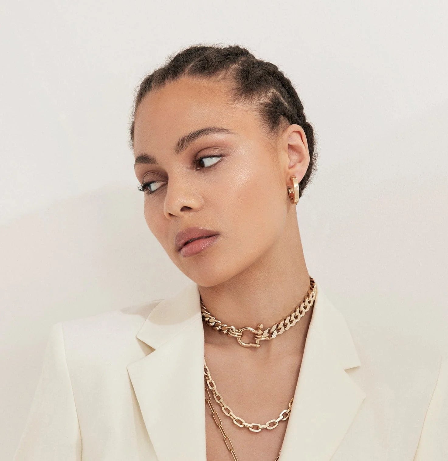 Woman wearing elegant gold jewelry featuring the Roxy Necklace