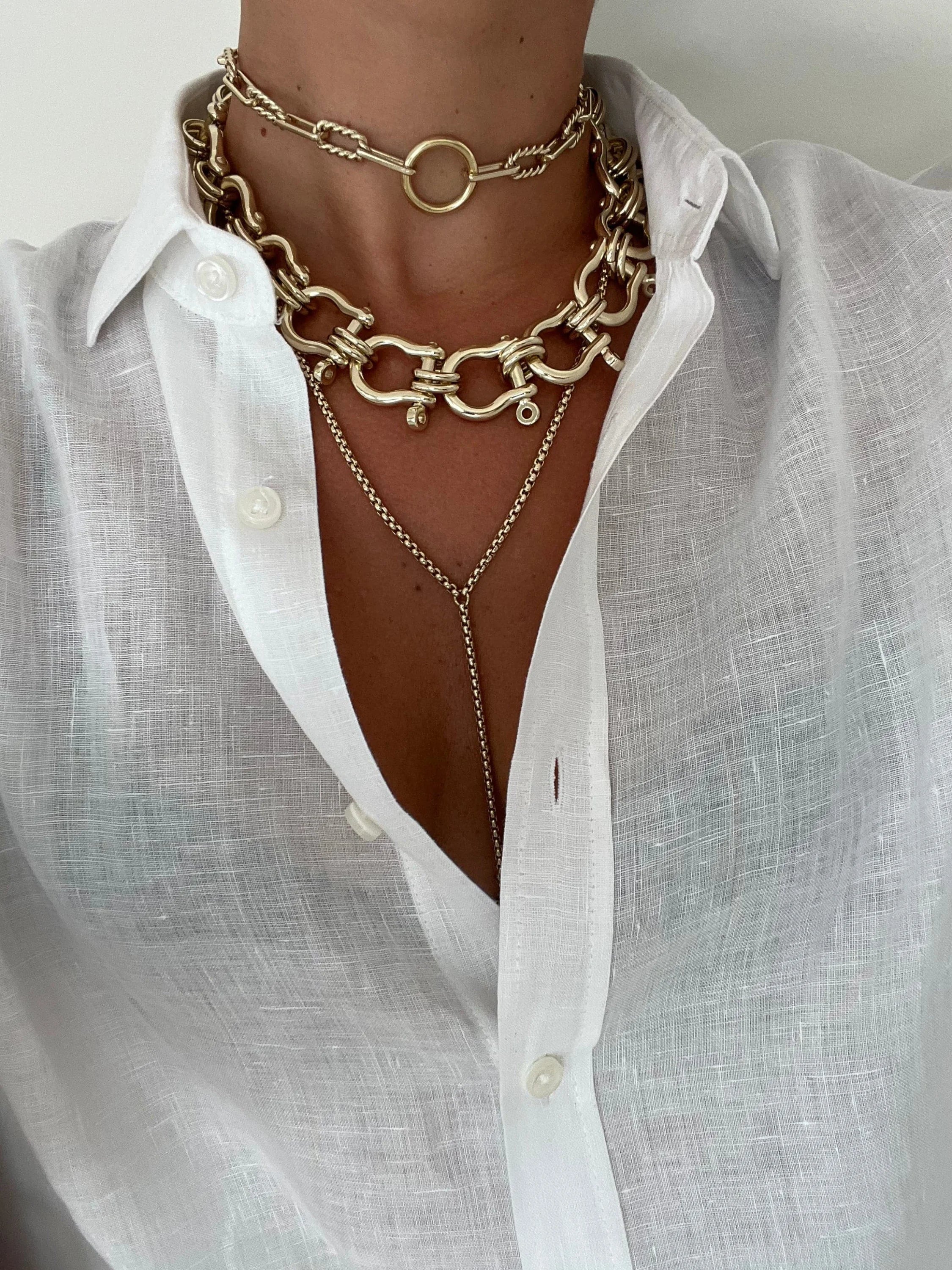 Eliza Necklace with layered gold necklaces and a white linen shirt