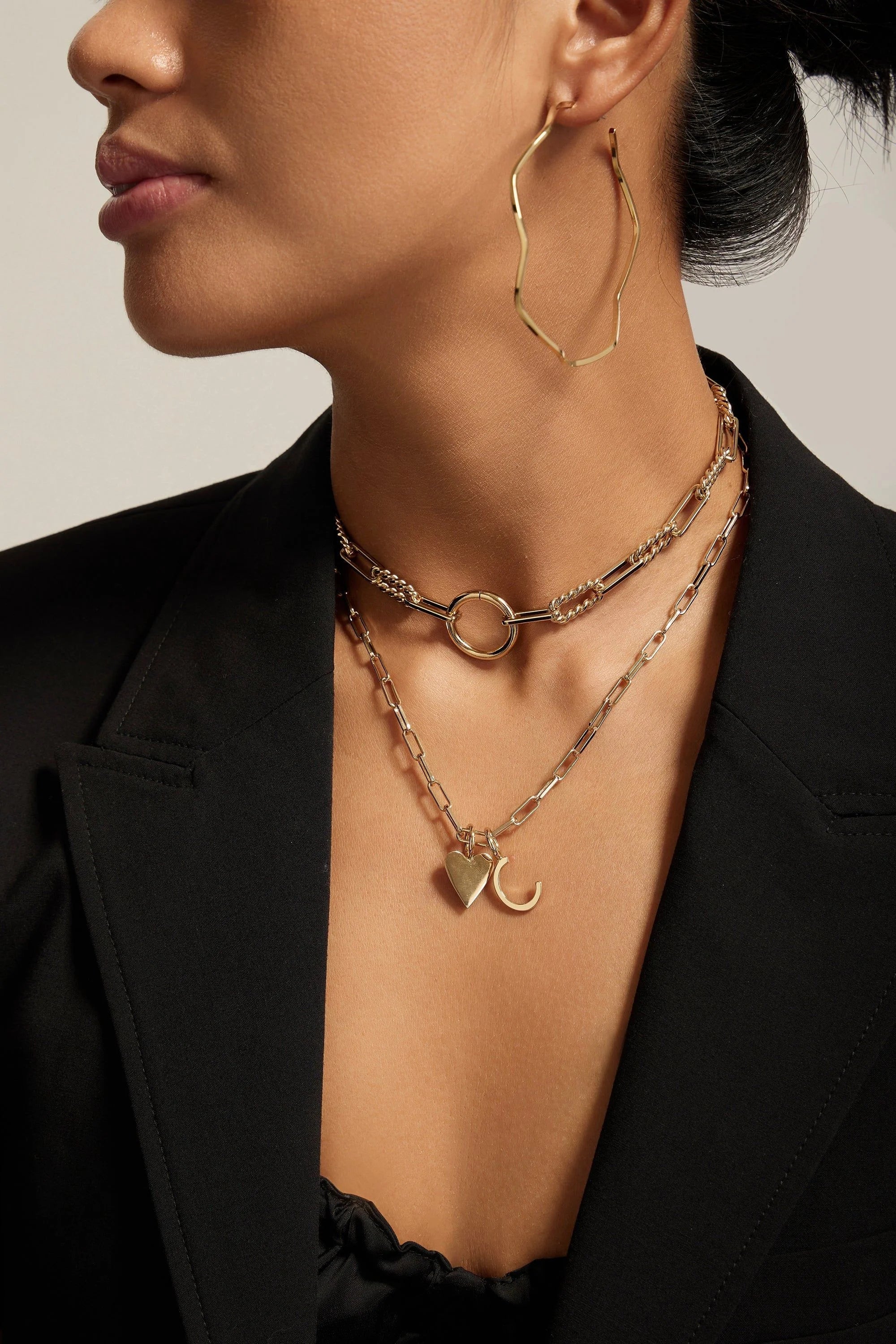 Woman wearing elegant 14k gold chain with elongated link design and recycled brass plating