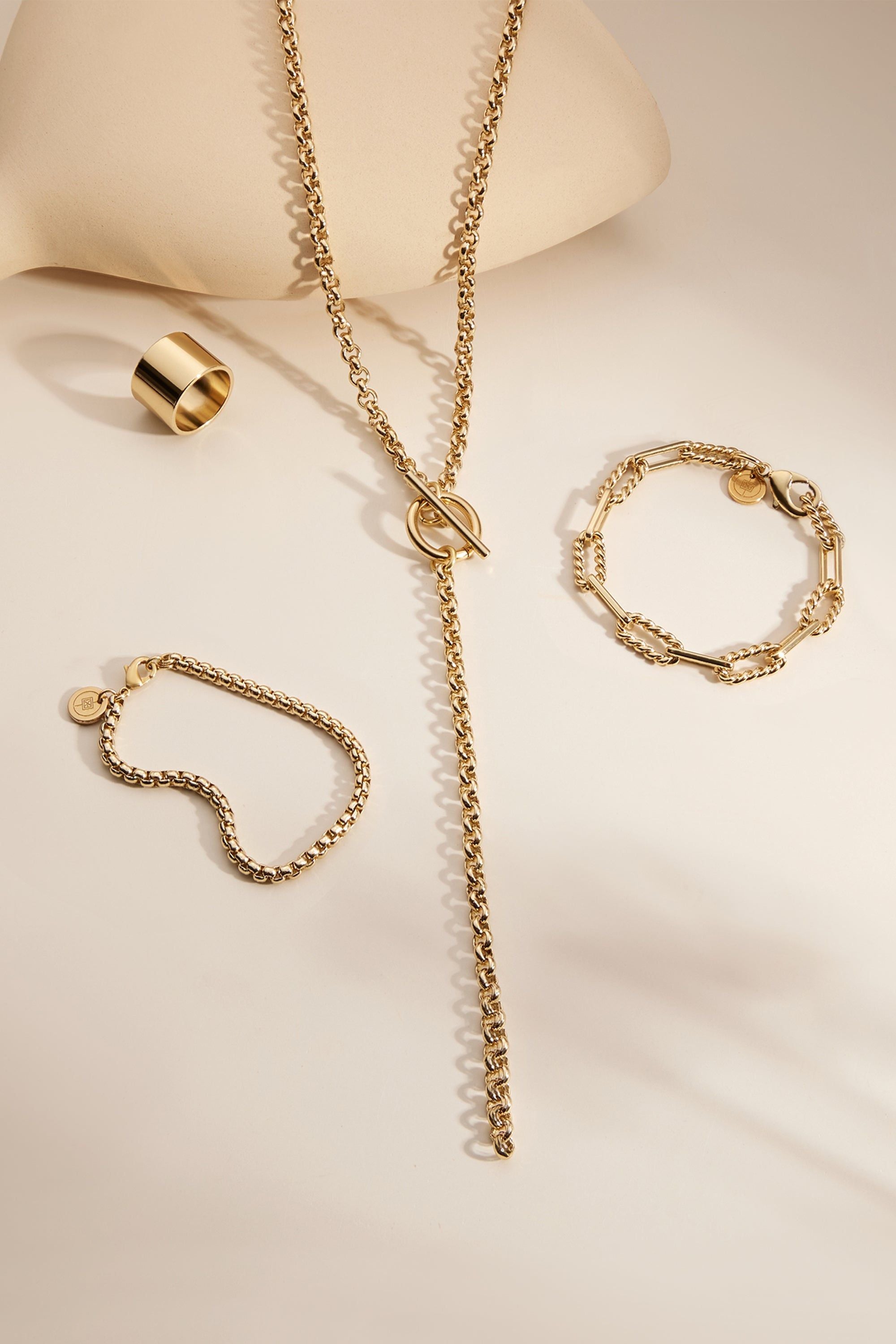 Gold-toned jewelry set featuring the Enzo Bracelet with alternating twisted link design