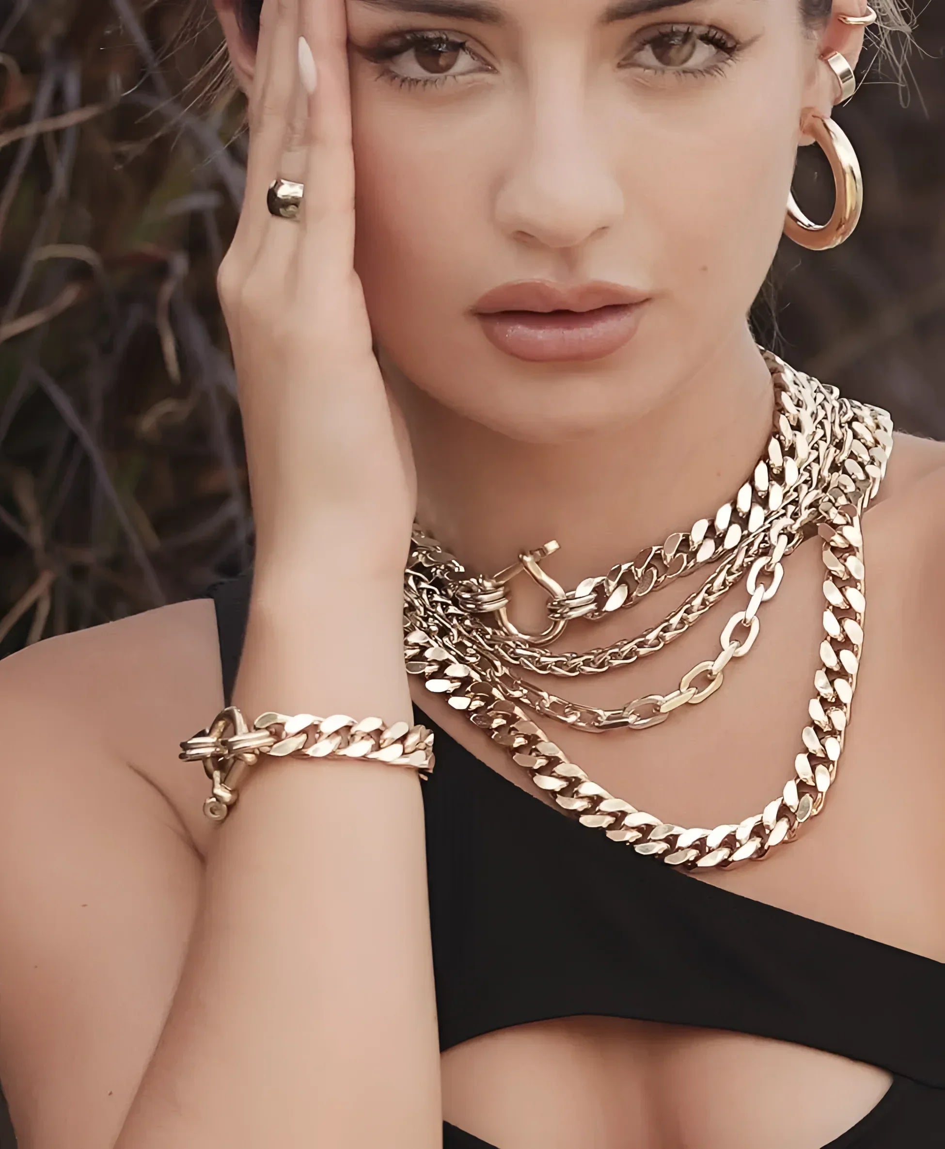 Woman wearing gold jewelry showcasing the Esmé Necklace style