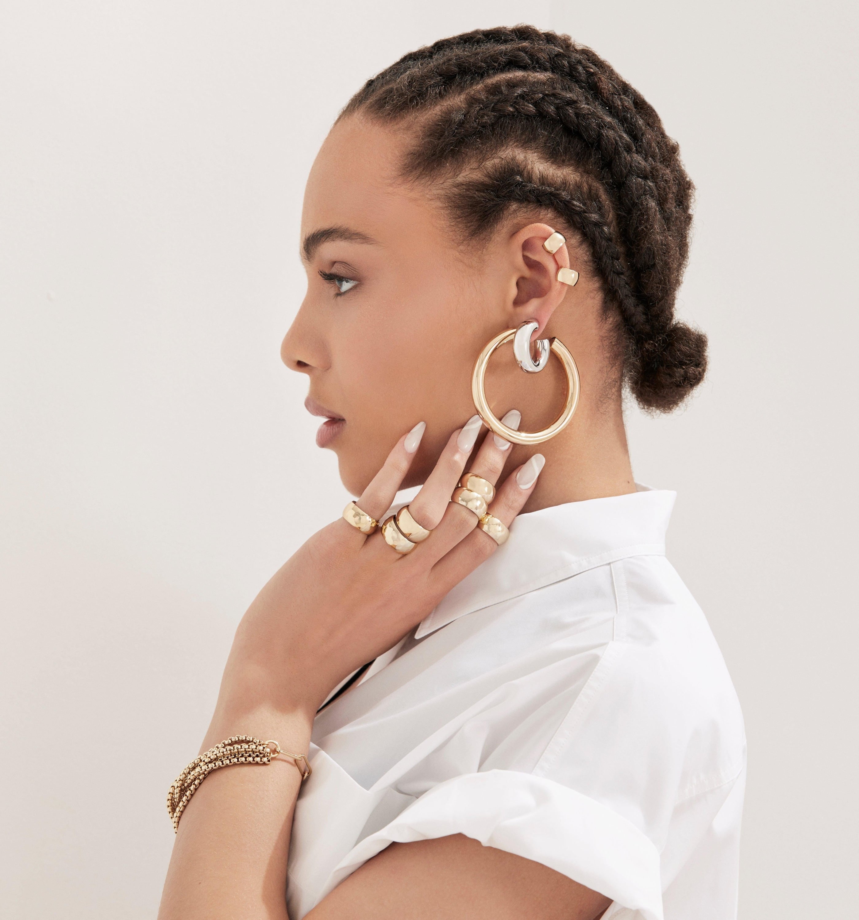 Woman showcasing the daring Gordon Ear Cuff with elegant gold jewelry