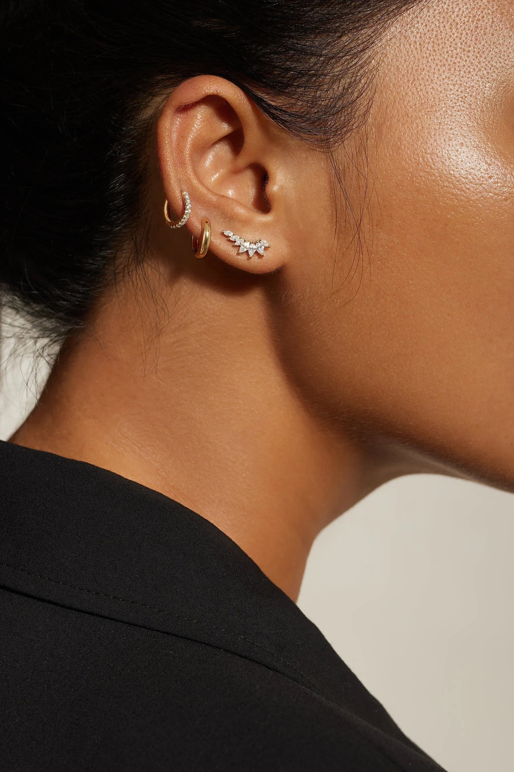 Ear with multiple earrings wearing Graduated Marquis Shaped CZ Ear Crawl jewelry