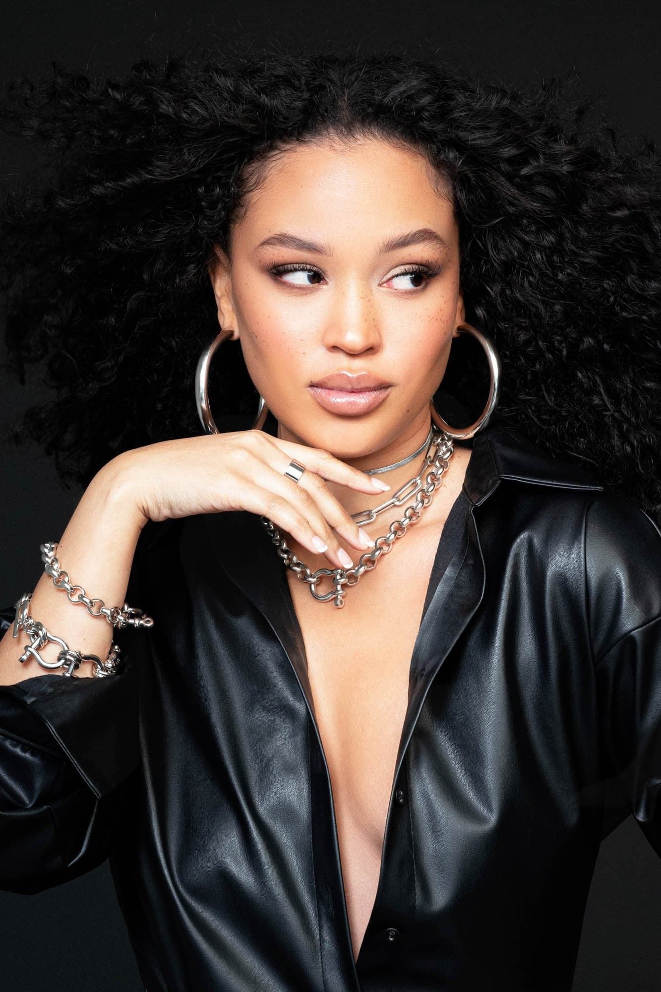 Woman in black leather shirt showcasing powerful wrist stack with Harley Bracelet and silver jewelry