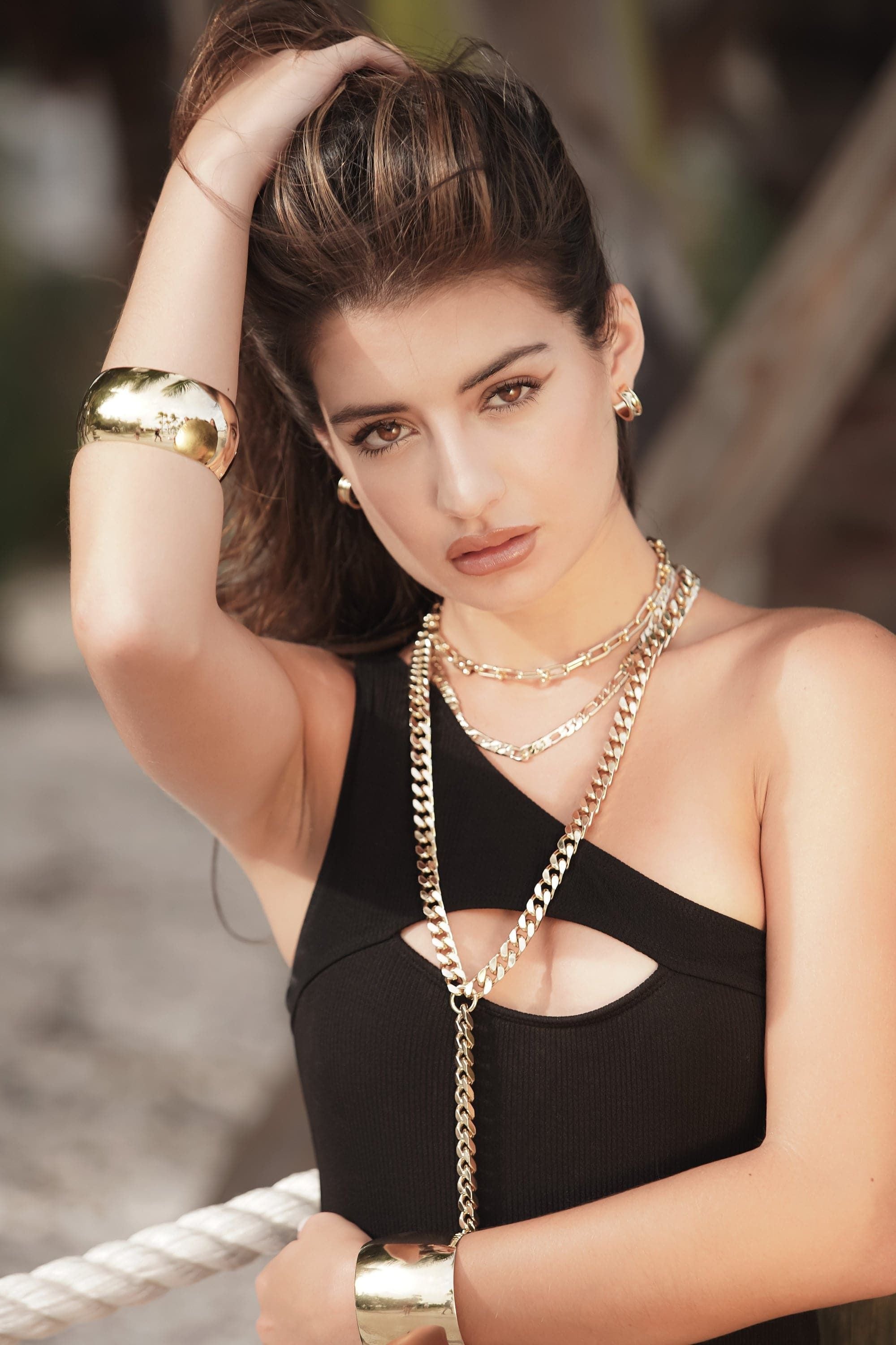 Woman showcasing a large domed bangle in gold, made of recycled brass