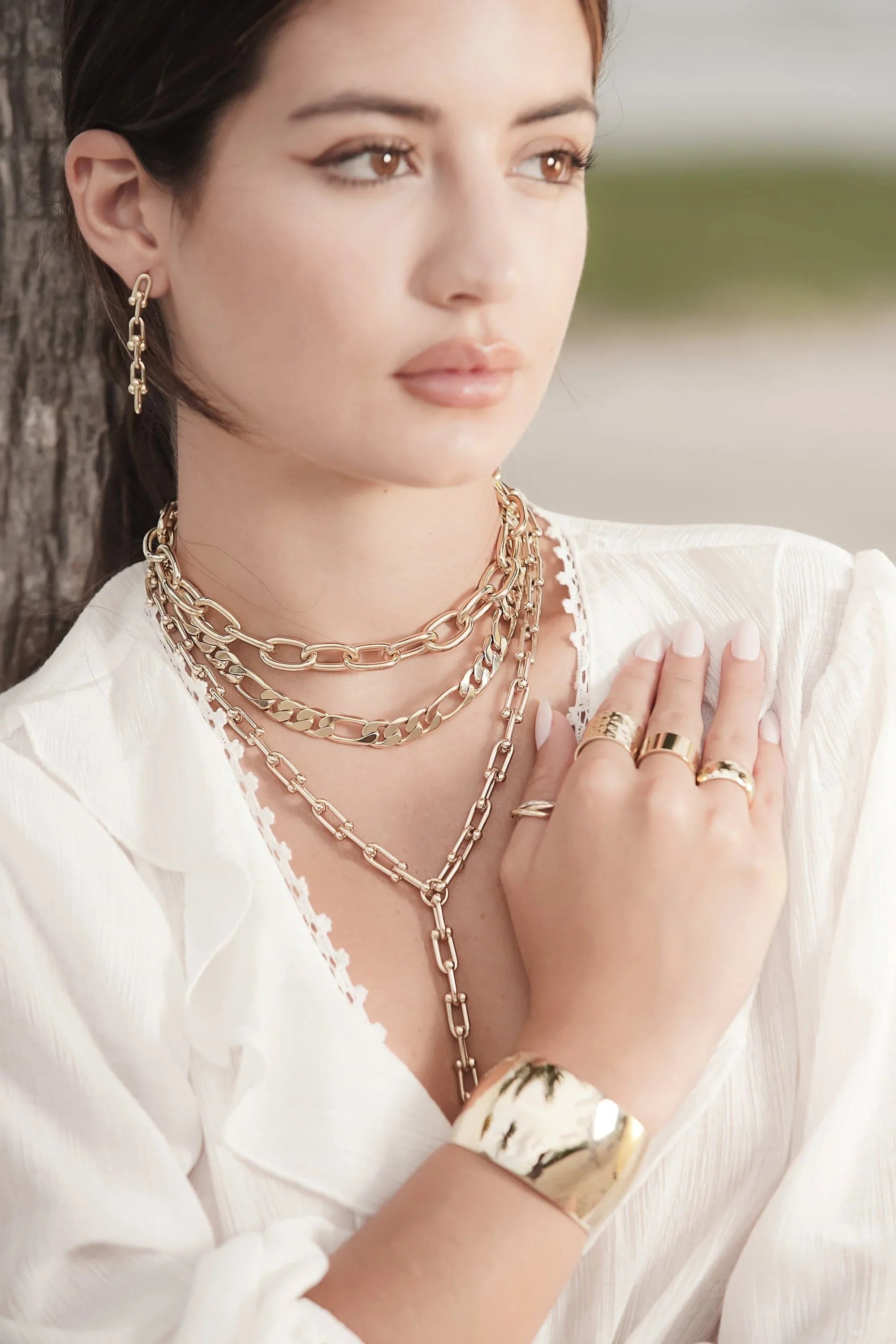 Woman wearing gold jewelry with a Large Domed Cuff on her wrist