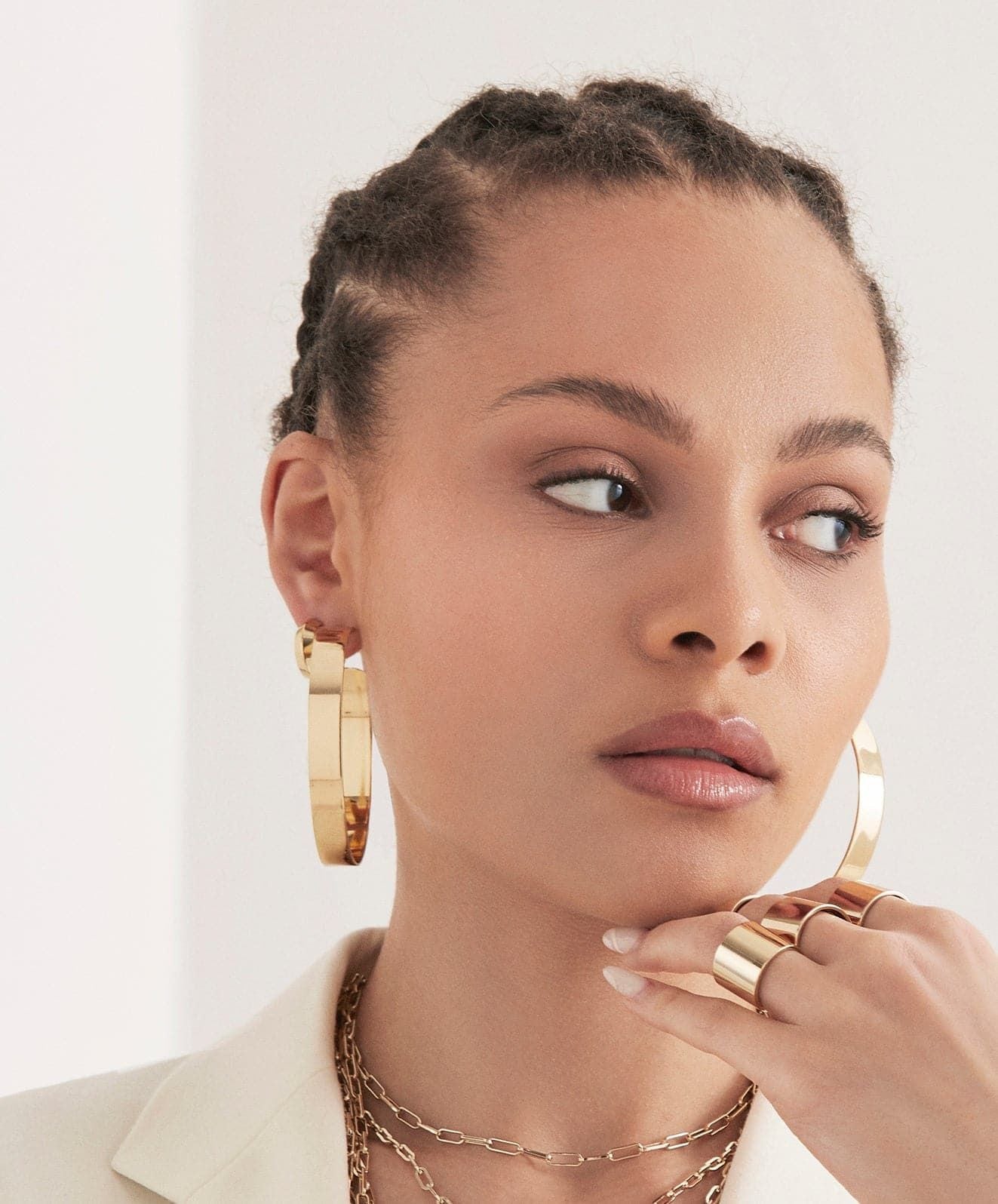 Woman showcasing large flat hoops and gold jewelry for a stylish look