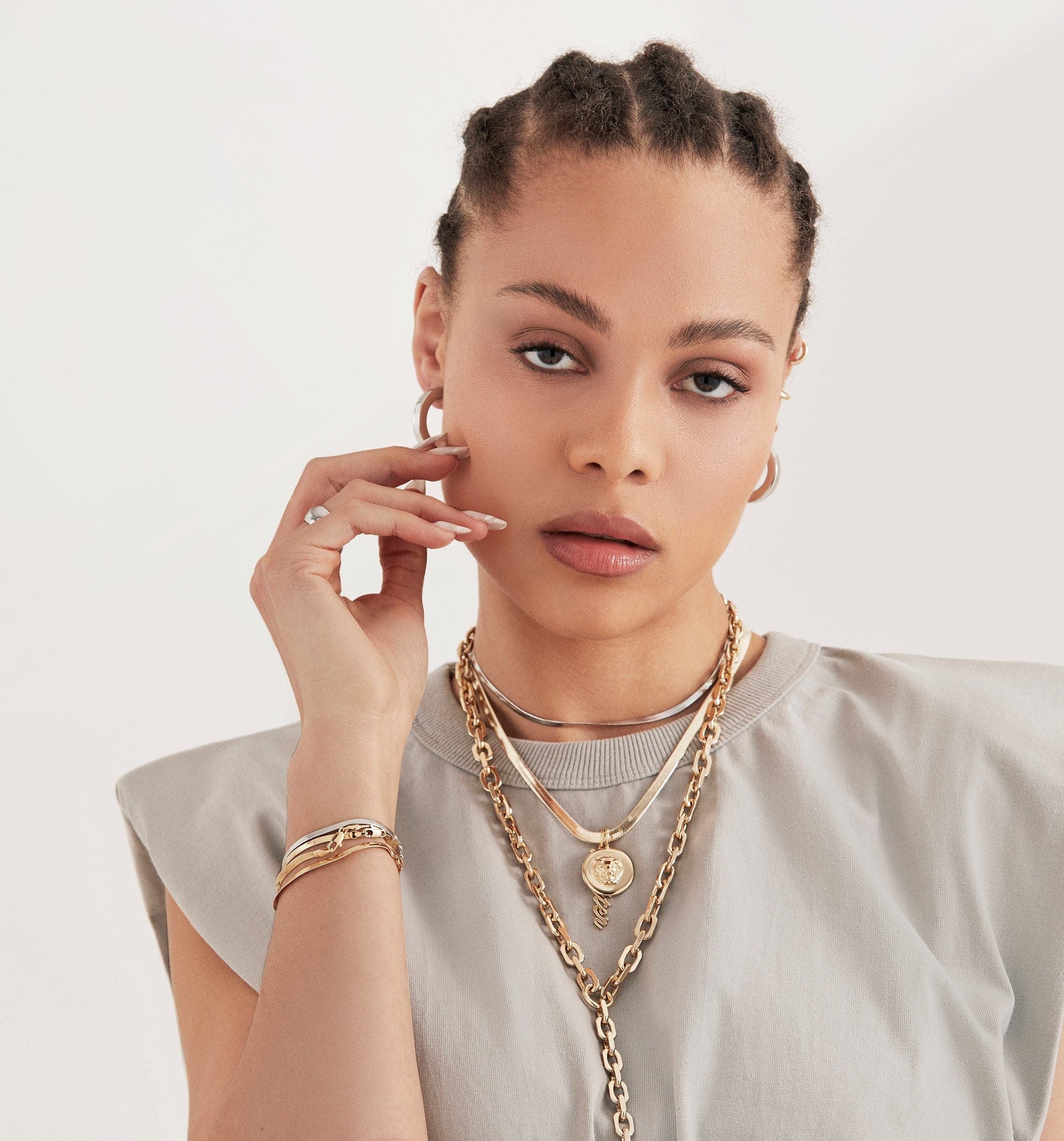 Woman showcasing the Leni Lion Pendant made of recycled brass in gold jewelry