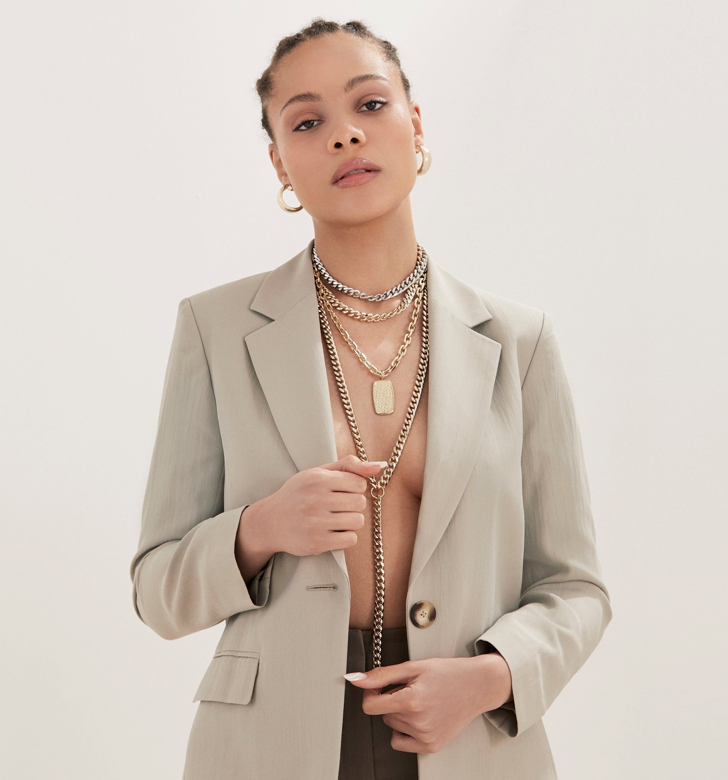 Woman in a blazer showcasing the Lenox Pendant with 14k gold barrel design