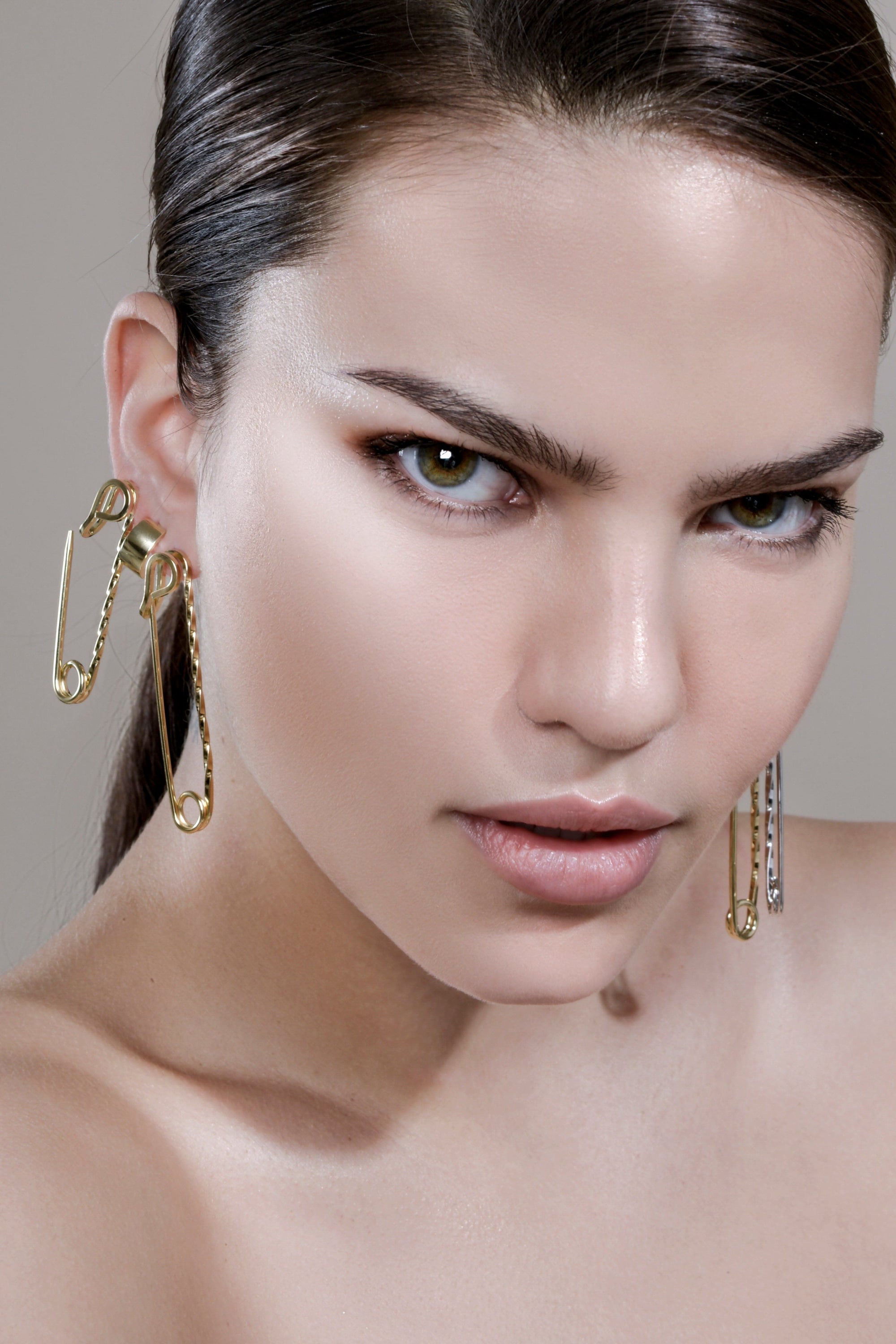 Woman showcasing Medium Twisted Safety Pin Earrings in 14k Yellow Gold design