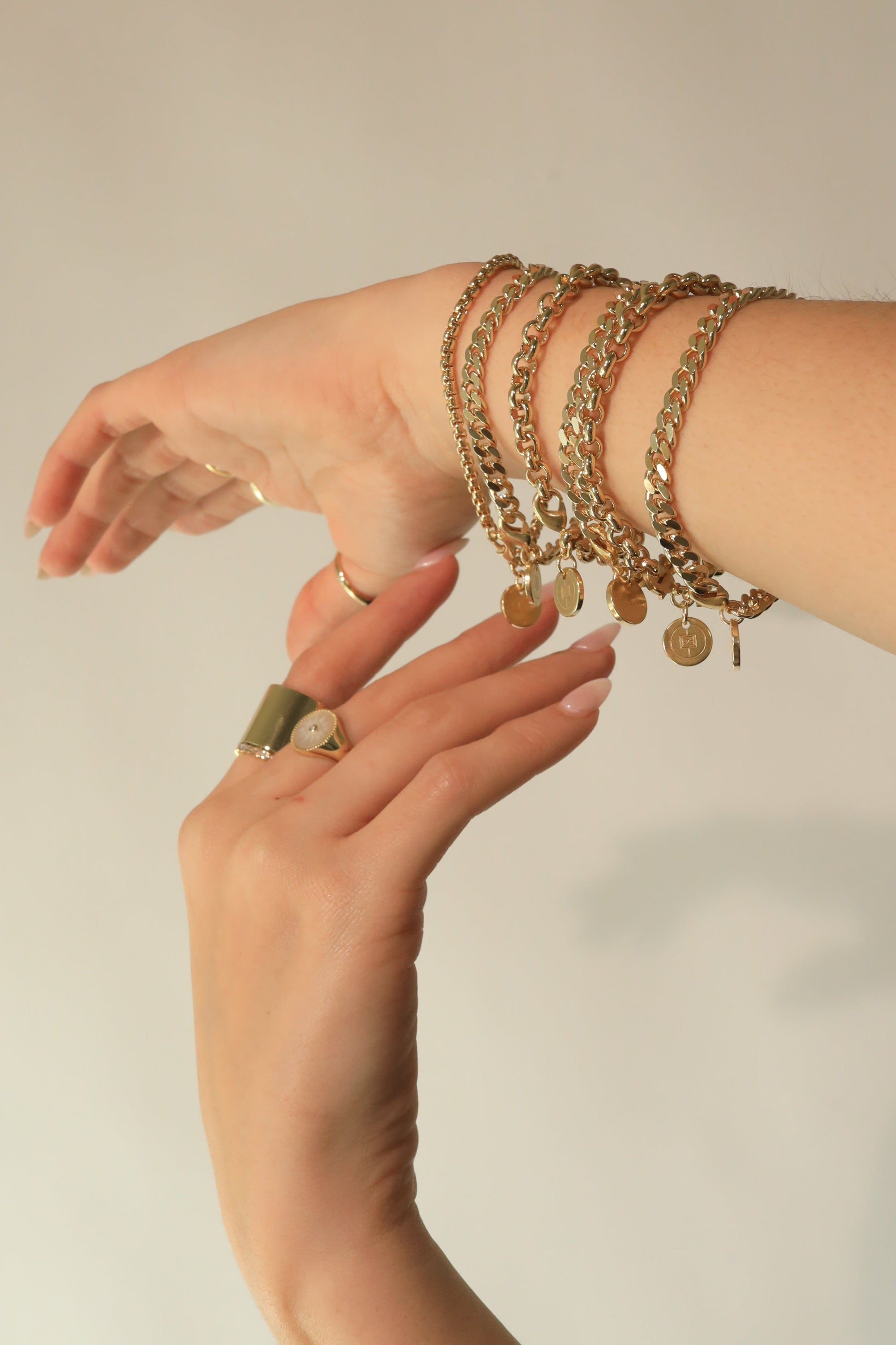 Gold chain bracelet with coin charms in Ecoat Micro Rolo design and rhodium plating